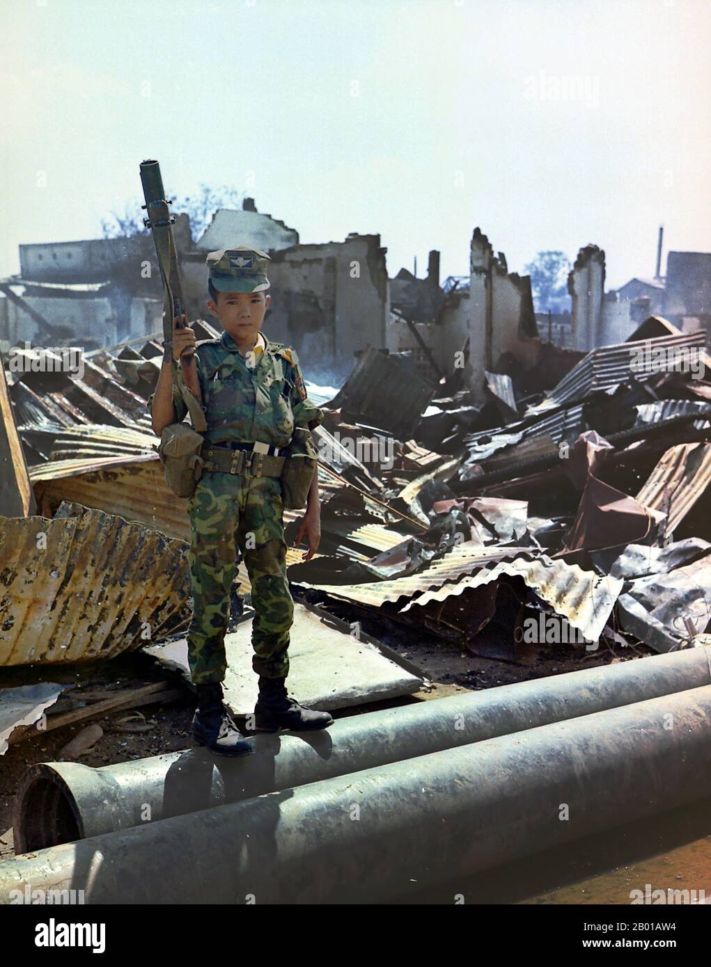 Vietnam: A twelve year old child soldier in Army of the Republic of Vietnam (ARVN) uniform, Tan Son Nhut Airport, Saigon, 7 May 1968.  A twelve year old Vietnamese ARVN Airborne trooper who had been 'adopted' by the Airborne Division, holding a M-79 grenade launcher. The picture was taken during a sweep of an Airborne Task Force Unit through the devastated area surrounding the French National Cemetery on Plantation Road after a day long battle there. Stock Photo