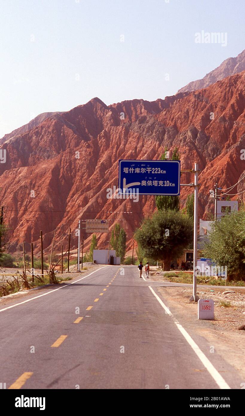 China: The red mountains of the Ghez River (Ghez Darya) canyon, Karakoram Highway.  The Zhongba Gonglu or Karakoram Highway is an engineering marvel that was opened in 1986 and remains the highest paved road in the world. It connects China and Pakistan across the Karakoram mountain range, through the Khunjerab Pass, at an altitude of 4,693 m/15,397 ft. Stock Photo