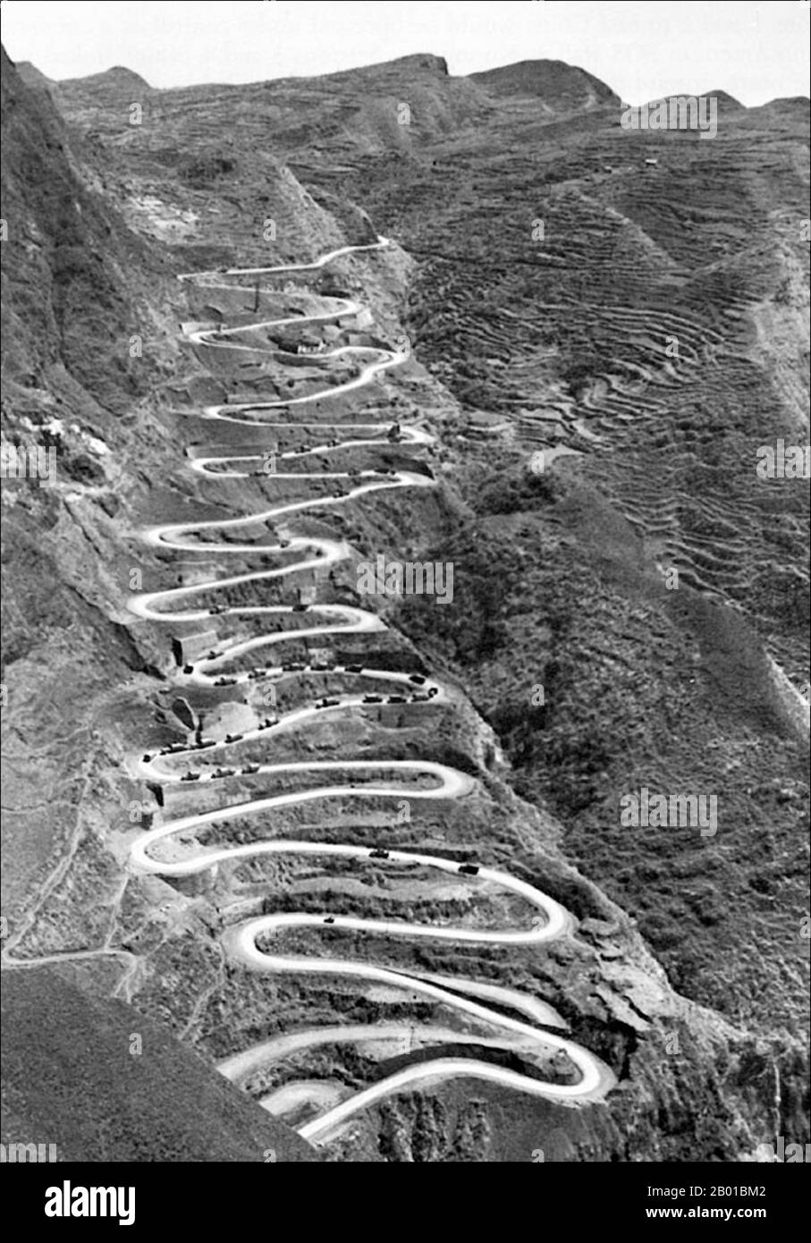 Burma/Myanmar/China: A convoy of military trucks on a section of the Burma Road, c. 1945.  The Burma Road is a road linking Burma (also called Myanmar) with China. Its terminals are Kunming, Yunnan, and Lashio, Burma. When it was built, Burma was a British colony under Japanese occupation.  The road is 717 miles (1,154 km) long and runs through rough mountain country. The sections from Kunming to the Burmese border were built by 200,000 Chinese laborers during the Second Sino-Japanese War in 1937 and completed by 1938. It had a role in World War II, when the British used the Burma Road. Stock Photo