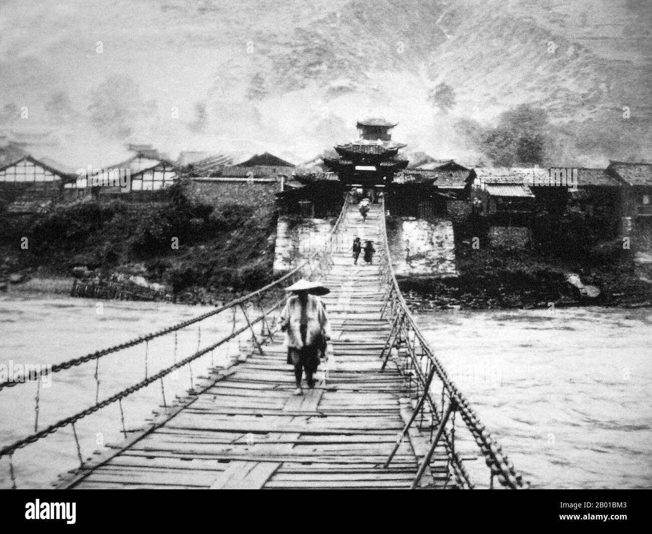 China: Muleteers crossing the Luding Bridge over the Dadu River in Luding County, Garze Tibetan Autonomous Prefecture, Sichuan. Photo by Auguste Francois (20 August 1857 - 4 July 1935), c. 1900.  The Tea Horse Road (Cha Ma Dao) was a network of mule caravan paths winding through the mountains of Yunnan, Sichuan and Tibet in Southwest China. It is also sometimes referred to as the Southern Silk Road and Ancient Tea Horse Road. From around a thousand years ago, the Ancient Tea Route was a trade link from Yunnan, one of the first tea-producing regions, to India via Myanmar. Stock Photo