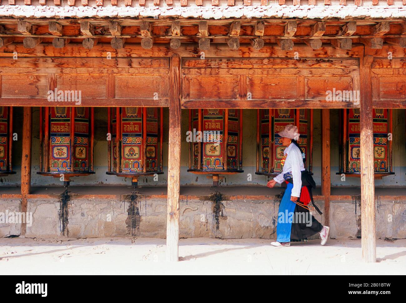 China: Pilgrims circumambulate the monastery while spinning the prayer wheels, Labrang Monastery, Xiahe, Gansu province.  Labrang Monastery is one of the six great monasteries of the Gelug (Yellow Hat) school of Tibetan Buddhism. Its formal name is Gandan Shaydrup Dargay Tashi Gyaysu Khyilway Ling, commonly known as Labrang Tashi Khyil, or simply Labrang. The monastery was founded in 1709 by the first Jamyang Zhaypa, Ngawang Tsondru. It is Tibetan Buddhism's most important monastery town outside the Tibetan Autonomous Region. Stock Photo