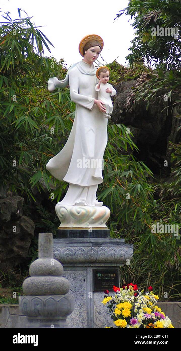 Vietnam: Our Lady of Phat Diem Cathedral - the Virgin Mary, clad in a Vietnamese ao dai dress, carries the infant Jesus. Photo by Tango7174 (CC BY-SA 4.0 License).  The ao dai (Vietnamese: áo dài) is a Vietnamese national costume, now most commonly for women. In its current form, it is a tight-fitting silk tunic worn over pantaloons. The word is pronounced ow-zye in the north and ow-yai in the south, and translates as 'long dress'.  The name áo dài was originally applied to the dress worn at the court of the Nguyễn Lords at Huế in the 18th century. This outfit evolved into the áo ngũ thân. Stock Photo