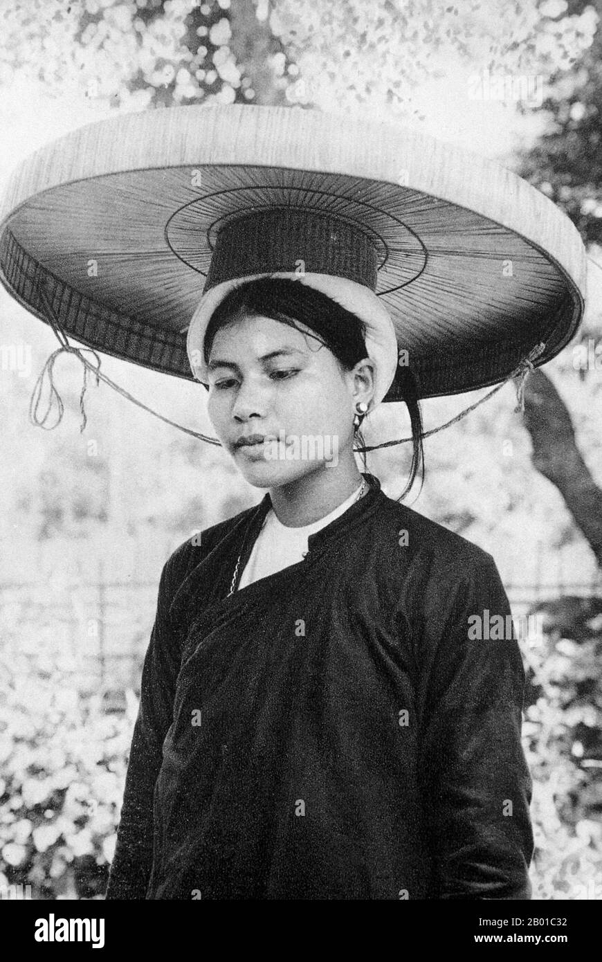 A woman of Tonkin, with a cartwheel hat (known as a Non Quai Thao or 'coarse silk strap hat'), Cho Bo town, c. 1920.  Tonkin (Bắc Kỳ in Vietnamese), sometimes spelled Tongkin, Tonquin or Tongking, is the northernmost part of Vietnam, south of China's Yunnan and Guangxi Provinces, east of northern Laos, and west of the Gulf of Tonkin. Locally, it is known as Bắc Kỳ, meaning 'Northern Region'. The name Tonkin comes from the Chinese meaning 'Eastern Capital'. Stock Photo