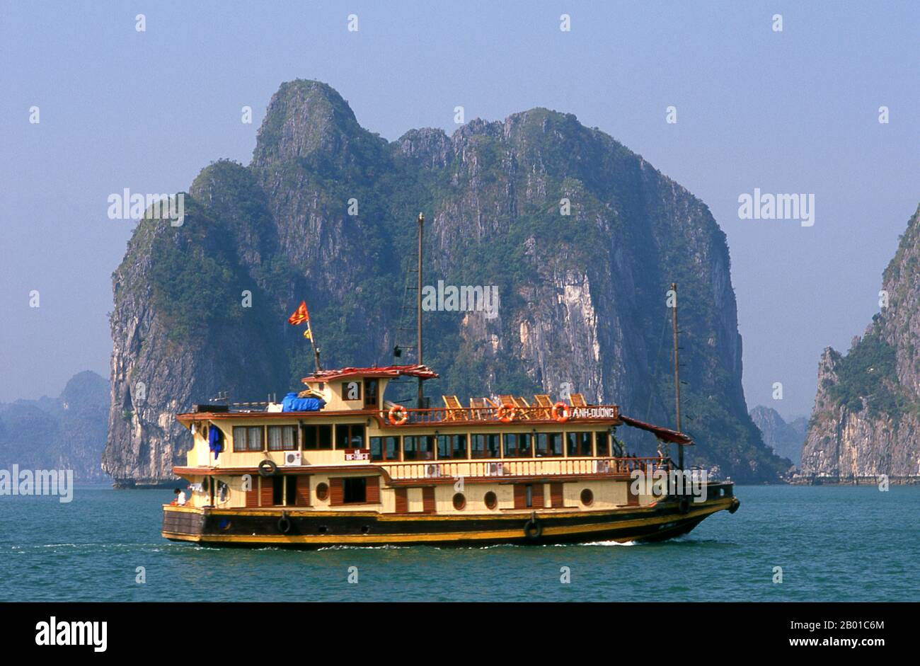 Vietnam: A tour boat in Halong Bay, Quang Ninh Province.  In Vietnamese ha long means ‘descending dragon’, and legend has it that Halong Bay was formed by a gigantic dragon which plunged into the Gulf of Tonkin, creating thousands of limestone outcrops by the lashing of its tail. Geologists tend to dismiss this theory, arguing that the myriad islands that dot Halong Bay and extend all the way north to the Chinese frontier are the product of selective erosion of the seabed over millennia. Stock Photo
