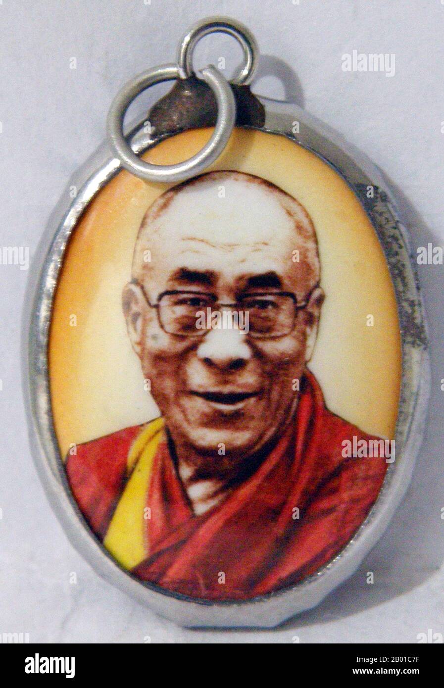 Tibet/China/India: Tibetan Buddhist amulet of the 14th Dalai Lama, Tenzin Gyatso (6 July 1935-).  The 14th Dalai Lama (Religious name: Tenzin Gyatso, shortened from Jetsun Jamphel Ngawang Lobsang Yeshe Tenzin Gyatso, born Lhamo Dondrub) is the 14th and current Dalai Lama. Dalai Lamas are the most influential figure in the Gelugpa lineage of Tibetan Buddhism, although the 14th has consolidated control over the other lineages in recent years.  He won the Nobel Peace Prize in 1989, and is also well known for his lifelong advocacy for Tibetans inside and outside Tibet. Stock Photo
