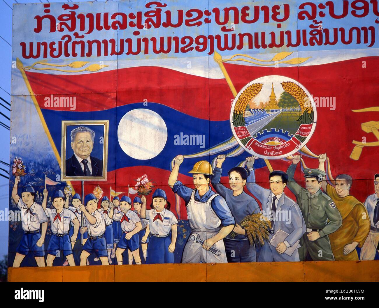 Laos: Children carry an image of Kaysone Phomvihane, President of Laos from 1991 until his death in 1992, Revolutionary Socialist realist-style political poster on the streets of Vientiane.  Kaysone Phomvihane (13 December 1920 - 21 November 1992) was the leader of the Lao People's Revolutionary Party from 1955. He served as the first Prime Minister of the Lao People's Democratic Republic from 1975 to 1991 and then as President from 1991 until his death in 1992. Stock Photo