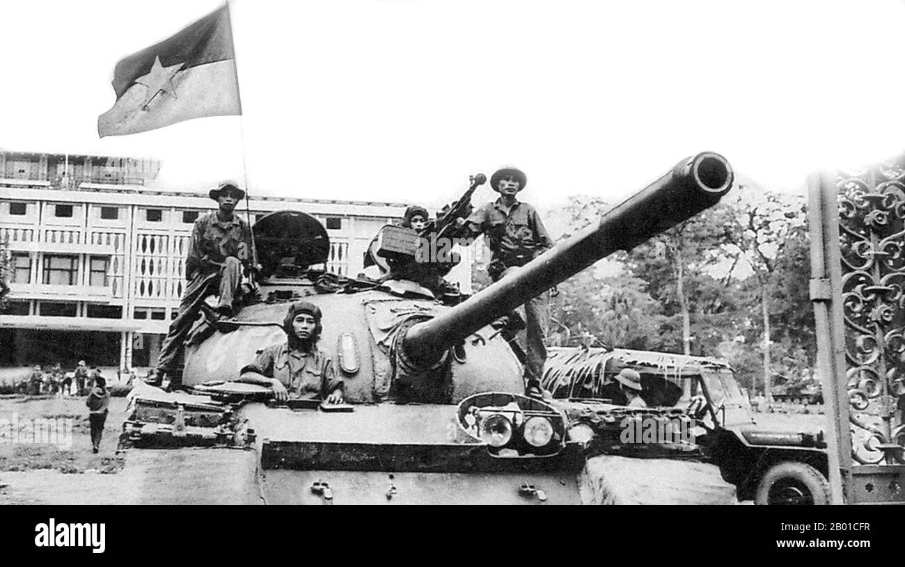 Vietnam: Tank of the North Vietnamese Army flying the NLF flag at the Presidential Palace (now Reunification Palace, Saigon, April 1975.  The Fall of Saigon was the capture/liberation of Saigon, the capital of South Vietnam, by the People's Army of Vietnam and the National Liberation Front on April 30, 1975. The event marked the end of the Vietnam War and the start of a transition period leading to the formal reunification of Vietnam under communist rule. Stock Photo