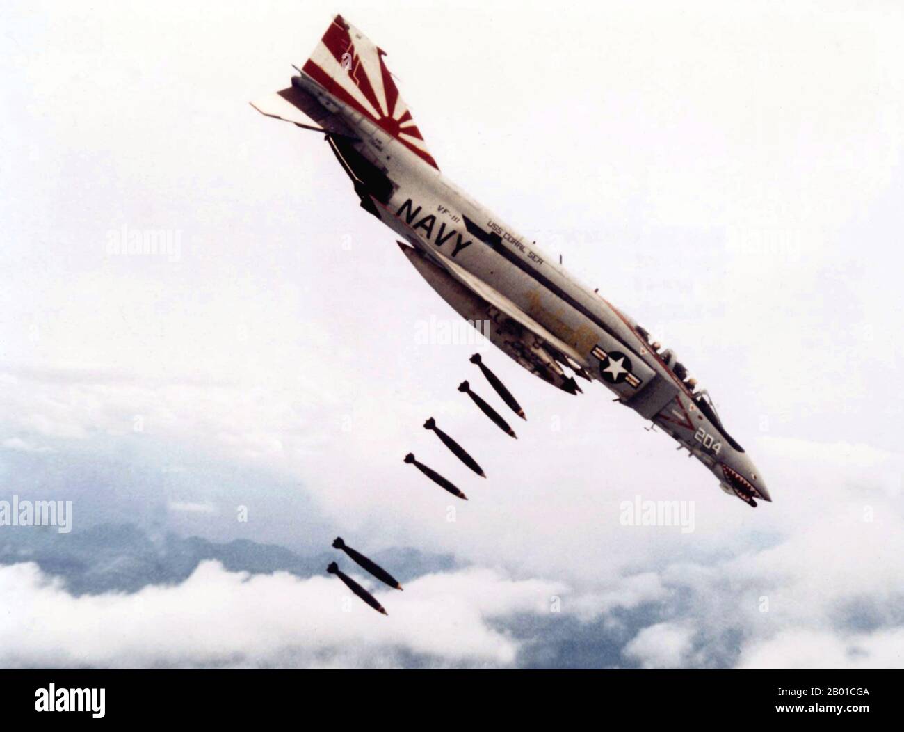 Vietnam: A US Navy McDonnell F-4B Phantom II from the USS Coral Sea drops bombs over Vietnam, 25  November 1971.  The Second Indochina War, known in America as the Vietnam War, was a Cold War era military conflict that occurred in Vietnam, Laos, and Cambodia from 1 November 1955 to the fall of Saigon on 30 April 1975. This war followed the First Indochina War and was fought between North Vietnam, supported by its communist allies, and the government of South Vietnam, supported by the U.S. and other anti-communist nations. Stock Photo
