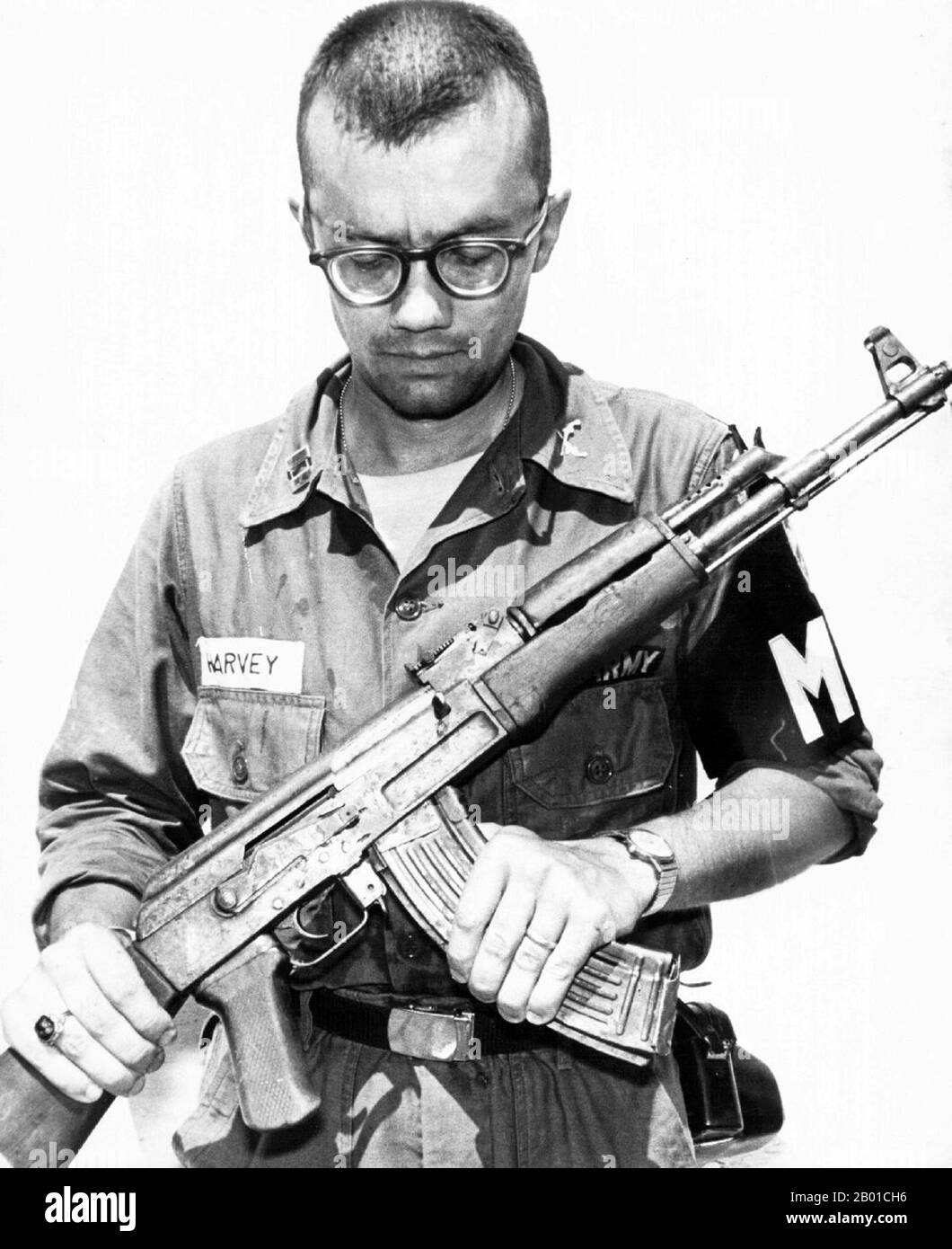 Vietnam: Captain Michael Harvey, US Army MP, inspects a captured National Liberation Front (Viet Cong) AK-47, 1968.  The AK-47 is a selective-fire, gas-operated 7.62×39mm assault rifle, first developed in the Soviet Union by Mikhail Kalashnikov. It is officially known as Avtomat Kalashnikova. It is also known as a Kalashnikov, an 'AK', or, in Russian slang, Kalash.  Design work on the AK-47 began in the last year of World War II (1945). After the war in 1946, the AK-46 was presented for official military trials. In 1947 the fixed-stock version was introduced into service with select units. Stock Photo