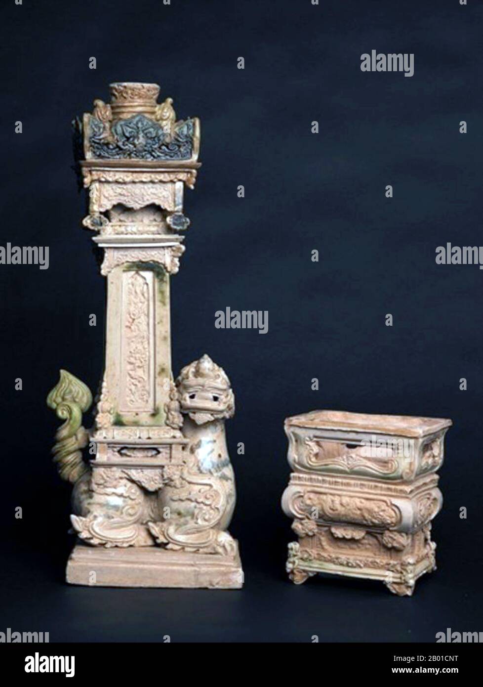 Vietnam: Altar pieces consisting of a large candle holder with a mythical beast sitting on a plinth with a tall pedestal upon its back. Later Lê Dynasty (1533-1788).  The top of the pedestal contains a rectangular platform with elegantly carved protrusions surrounding a round candle receptacle.   The attendant censer is in the style of bronze pieces of the era and sits on a reticulated pedestal base, sharing many of the same decorative touches of the candle-holder. Stock Photo