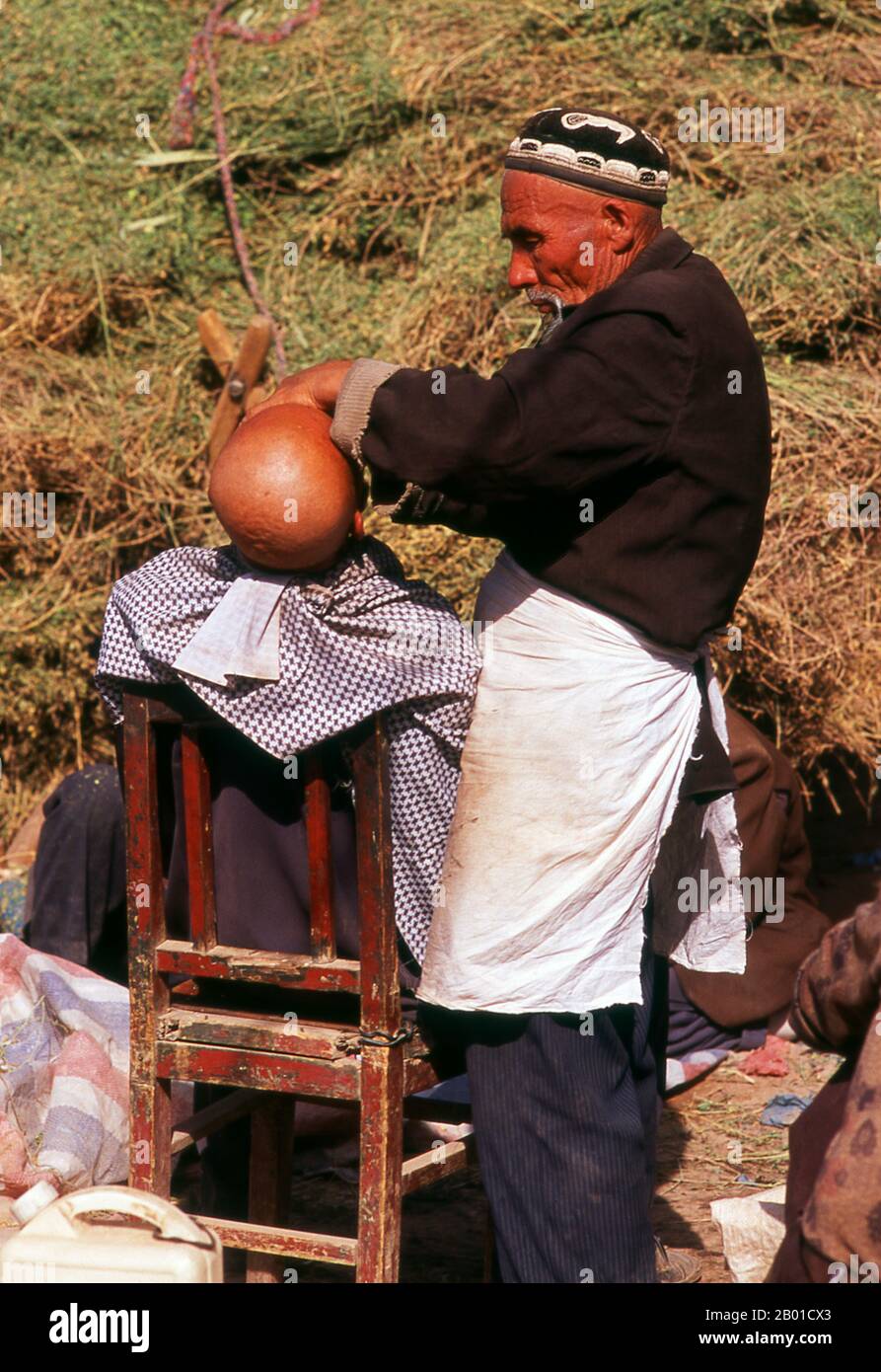 China: A shave in the sun, Kashgar, Xinjiang Province.  The earliest mention of Kashgar occurs when a Chinese Han Dynasty (206 BCE – 220 CE) envoy traveled the Northern Silk Road to explore lands to the west.  Another early mention of Kashgar is during the Former Han (also known as the Western Han Dynasty), when in 76 BCE the Chinese conquered the Xiongnu, Yutian (Khotan), Sulei (Kashgar), and a group of states in the Tarim basin almost up to the foot of the Tian Shan mountains. Stock Photo