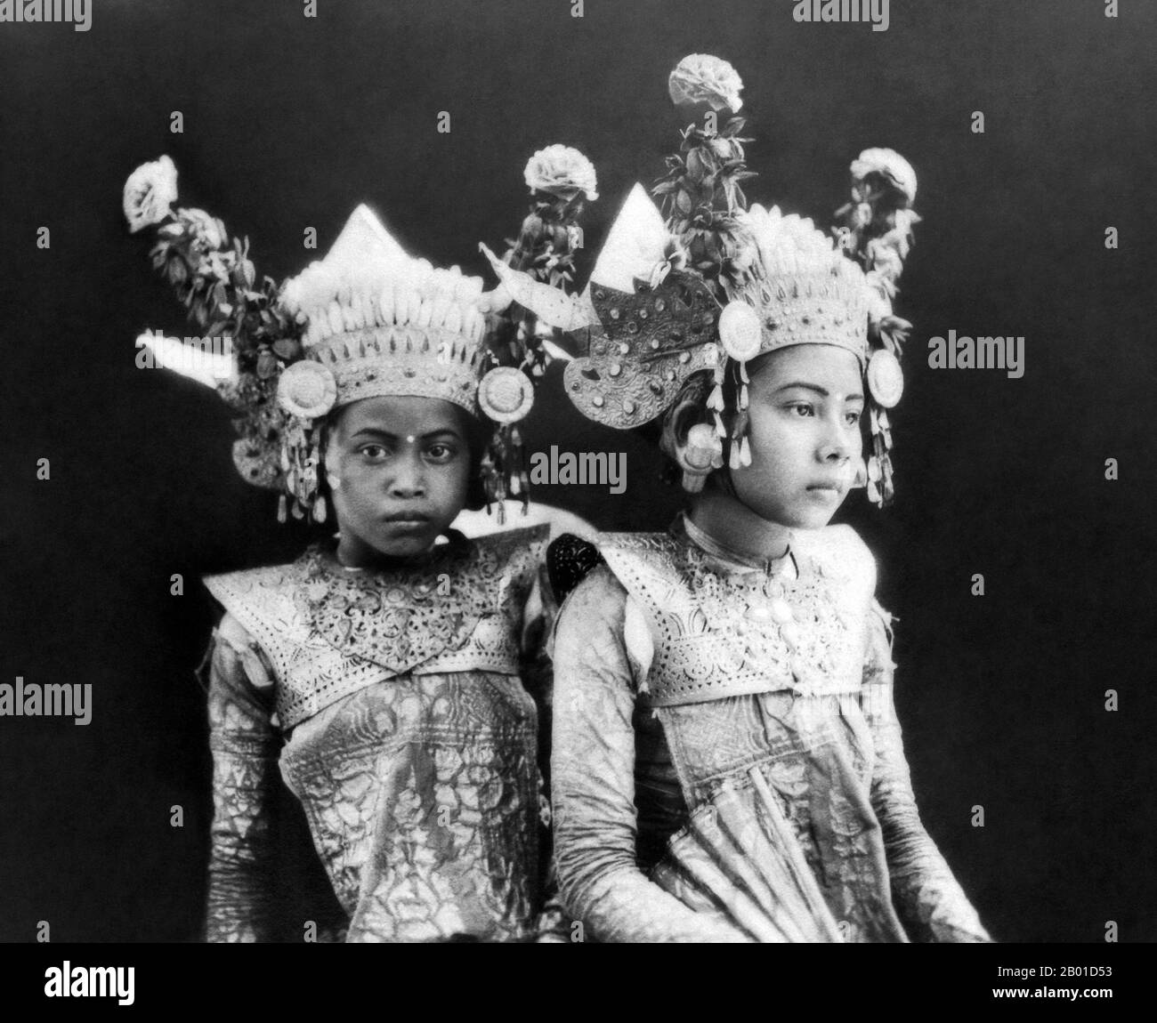 Indonesia: Two very young Legong dancers posing on the island of Bali, c. 1929.  Legong is a form of Balinese dance. It is a refined dance form characterised by intricate finger movements, complicated footwork, and expressive gestures and facial expressions.  Legong probably originated in the 19th century as royal entertainment. Legend has it that a prince of Sukwati fell ill and had a vivid dream in which two maidens danced to gamelan music. When he recovered, he arranged for such dances to be performed in reality. Stock Photo