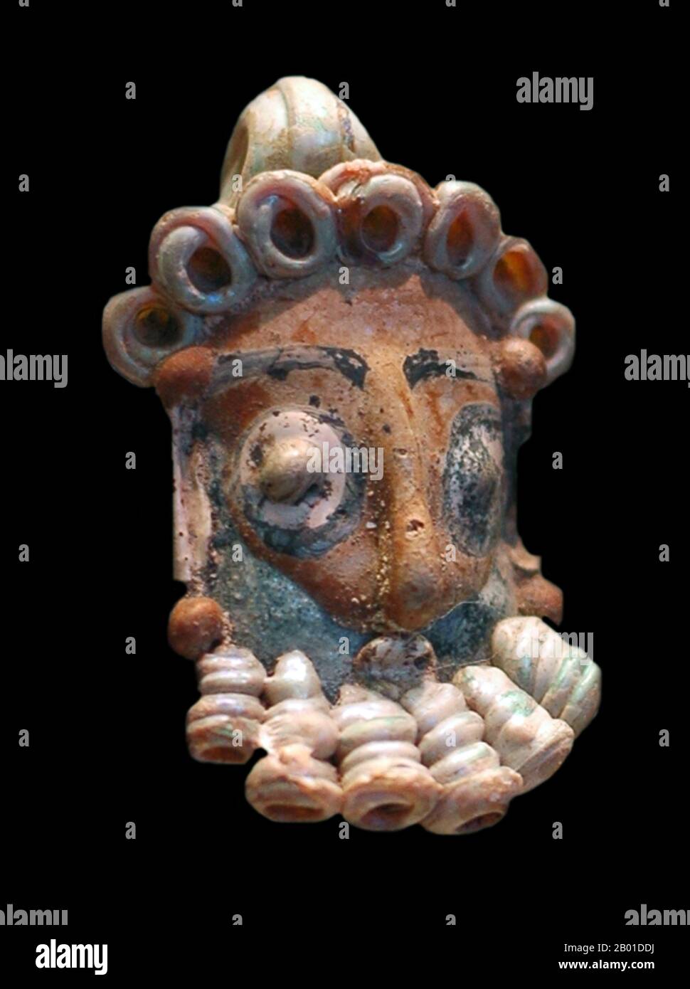 Tunisia: Head of a bearded man, coloured glass, Carthage, 4th-3rd centuries BCE.  The head was possibly a pendant or part of a necklace  Carthage (Latin: Carthago or Karthago, Ancient Greek: Karkhēdōn, Arabic: Qarṭāj, Berber: Kartajen, meaning New City) is a major urban centre that has existed for nearly 3,000 years on the Gulf of Tunis, developing from a Phoenician colony of the 1st millennium BCE.  The first civilisation that developed within the city's sphere of influence is referred to as Punic (a form of the word Phoenician) or Carthaginian. Stock Photo