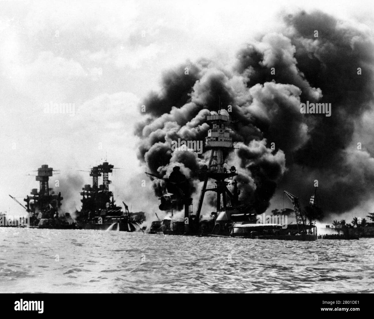 USA/Japan: The USS Tennessee and USS West Virginia (left) and the wreck of the USS Arizona, after the Japanese attack on Pearl Harbour, December 7, 1941.  The attack on Pearl Harbor was a surprise military strike conducted by the Imperial Japanese Navy against the United States naval base at Pearl Harbor, Hawaii, on the morning of December 7, 1941 (December 8 in Japan).  The attack was intended as a preventive action in order to keep the U.S. Pacific Fleet from interfering with military actions the Empire of Japan was planning in Southeast Asia. Stock Photo