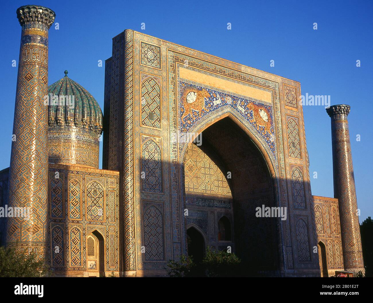 Uzbekistan: Minaret, fluted dome and portico at Sher Dor Madrassa, The Registan, Samarkand.  The Registan contains three madrasahs (schools), the Ulugh Beg Madrasah (1417–1420), Tilya-Kori Madrasah (1646–1660) and the Sher-Dor Madrasah (1619–1636).  In the 17th century the ruler of Samarkand Yalangtush Bakhodur ordered the construction of the Sher-Dor and Tillya-Kori madrasahs. The Sher-Dor (Having Tigers) Madrasah was designed by architect Abdujabor. The decoration of the madrasah is not as refined as that found on 15th century architecture, Samarkand's 'golden age'. Stock Photo