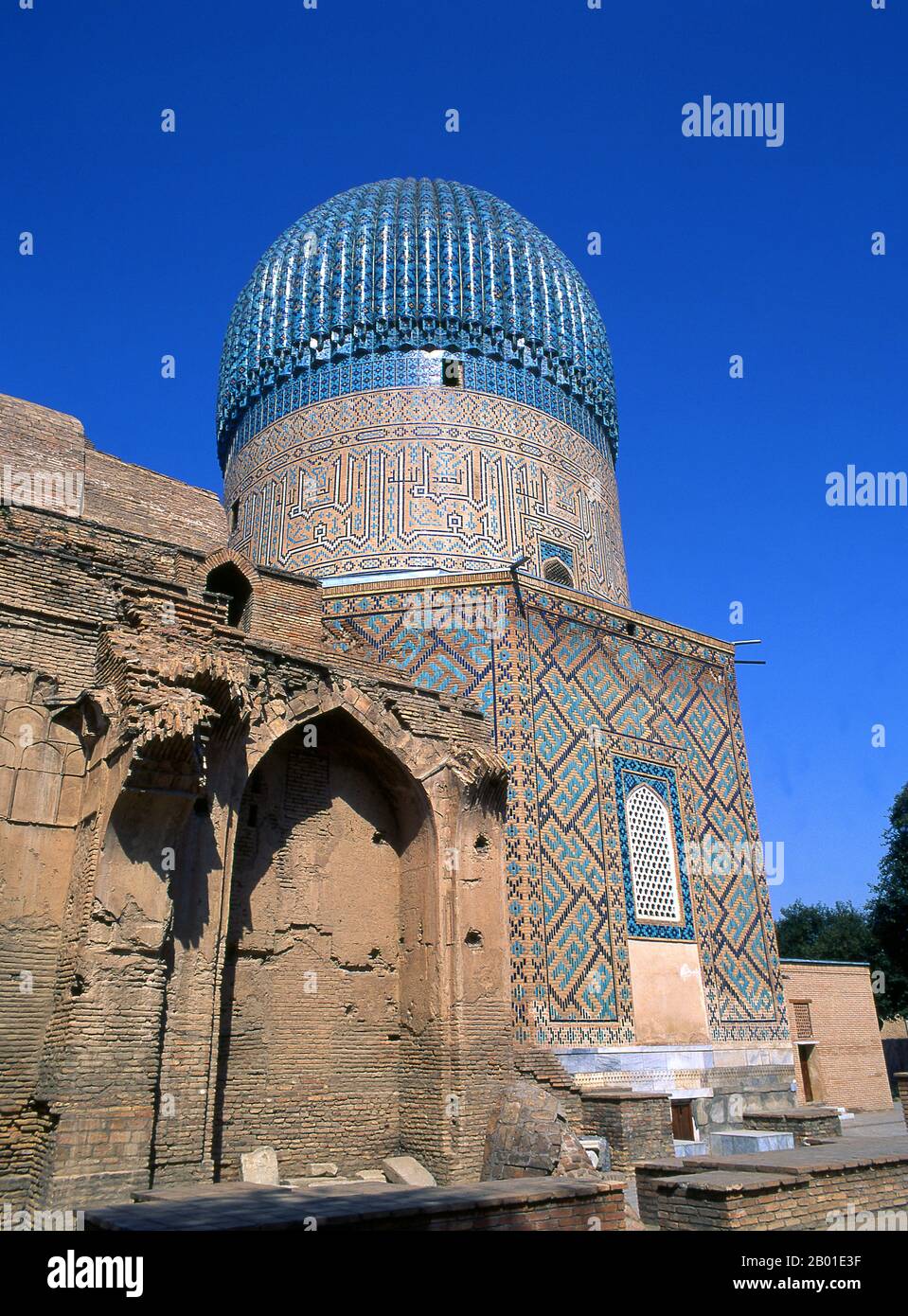 Uzbekistan: Timurid fluted dome, Gur-e Amir mausoleum, Samarkand.  The Gūr-e Amīr or Guri Amir (Persian: گورِ امیر) is the mausoleum of the Asian conqueror Tamerlane (also known as Timur) in Samarkand, Uzbekistan. It occupies an important place in the history of Persian architecture as the precursor and model for later great Mughal architecture tombs, including Humayun's Tomb in Delhi and the Taj Mahal in Agra, built by Timur's descendants, the ruling Mughal dynasty of North India. It has been heavily restored.  Gur-e Amir is Persian for 'Tomb of the King'. Stock Photo