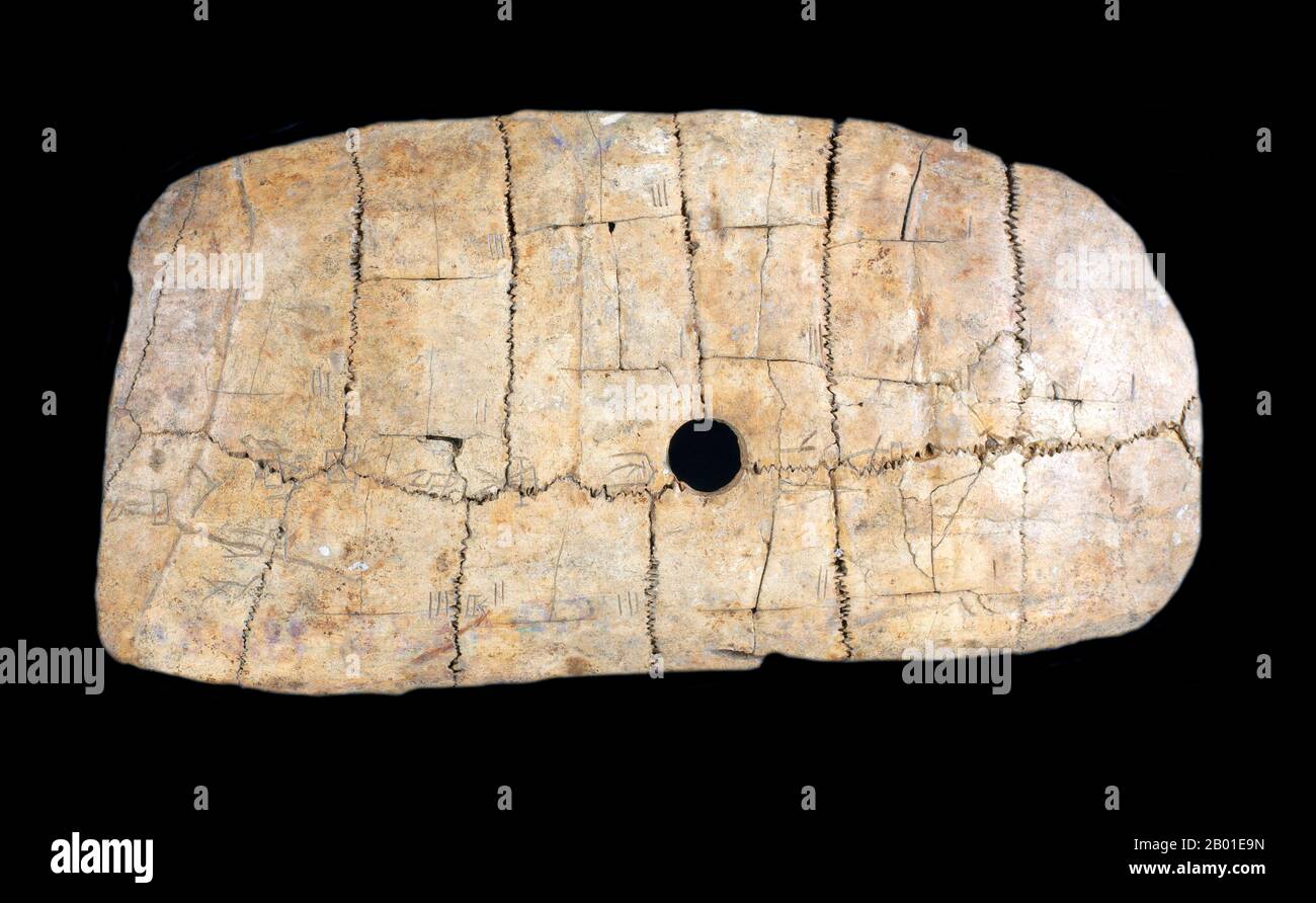 China: An oracle bone of turtle plastron pierced to be threaded on a string. Xiaotun, Anyang County, Henan Province, c. 1300-1050 BCE.  Oracle bone inscriptions (Chinese: 甲骨; pinyin: jiǎgǔ) are the ancient Chinese characters carved on animal scapulas (shoulder blades) or turtle plastron (underside).  The oracle bone inscriptions were mainly used for divination and keeping records of events that happened in the late Shang Dynasty (c. 1300-1050 BCE). Stock Photo