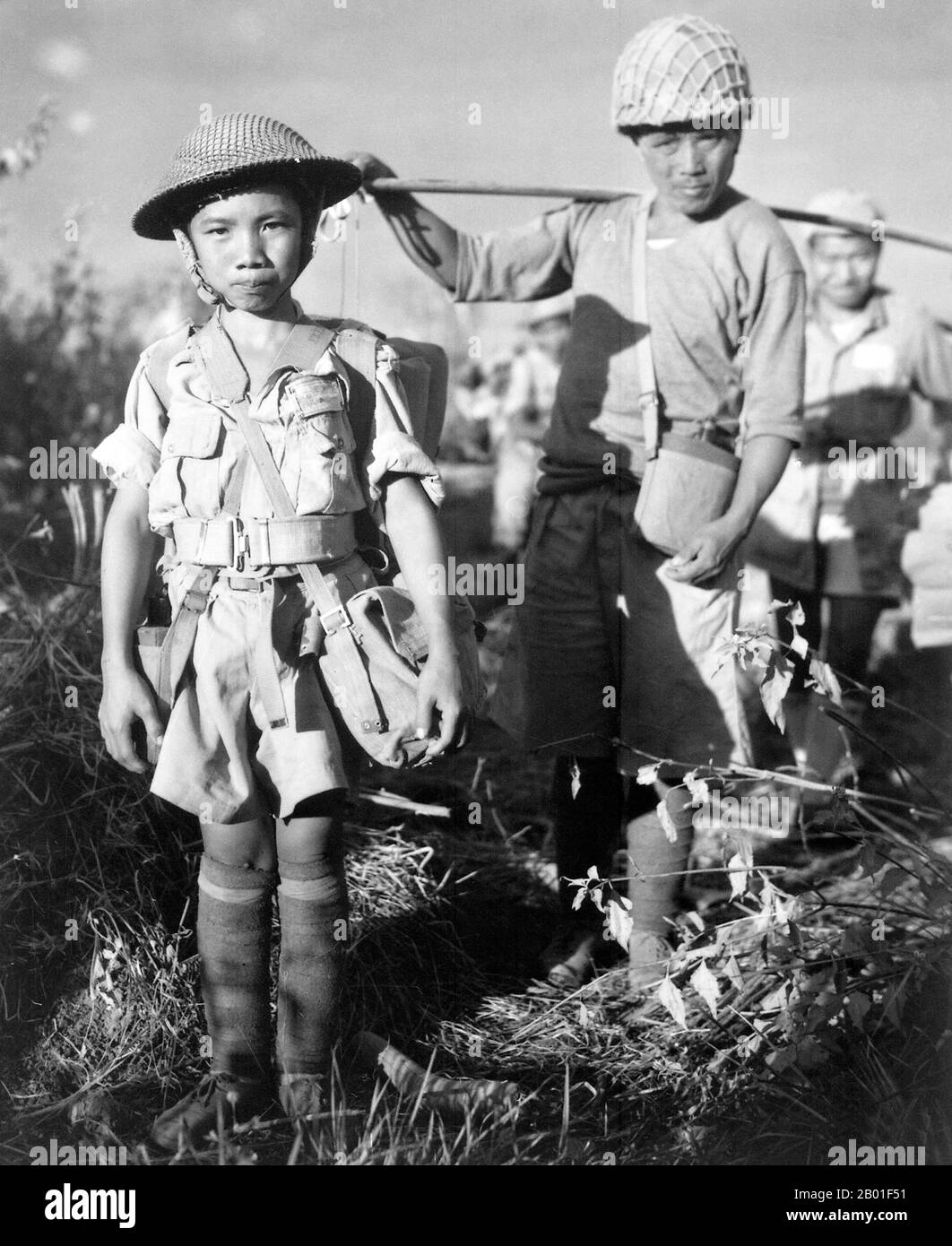 Burma/Myanmar: Chinese child soldier on the China-Burma-India Theatre at Myitkyina, May 1944.  This Chinese child soldier, age 10, with heavy pack, was a member of an army division boarding a plane returning them to China, following the capture of Myitkyina airfield, Burma, under the allied command of US Major General Frank Merrill.  Chinese and allied troops had earlier crossed through the treacherous jungle of the Kumon Bum Mountains before attacking Japanese troops to the south. Exhaustion and disease led to the early evacuation of many Chinese and allied troops before the coming assault. Stock Photo