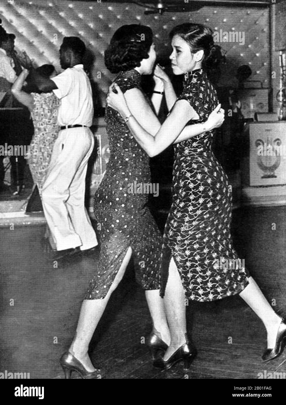 Vietnam: Taxi dancers dancing together at the Arc-en-Ciel Club on Jaccareo Road, Cholon, c. 1952.  The Arc-en-Ciel was arguably Saigon's top night spot during the 1940s and 1950s. Located in Saigon's twin city of Cholon on Jaccareo Avenue - today's Tan Da - it features prominently in Graham Greene's 'The Quiet American' as the taxi dance venue where Thomas Fowler met and wooed Phuong. Stock Photo