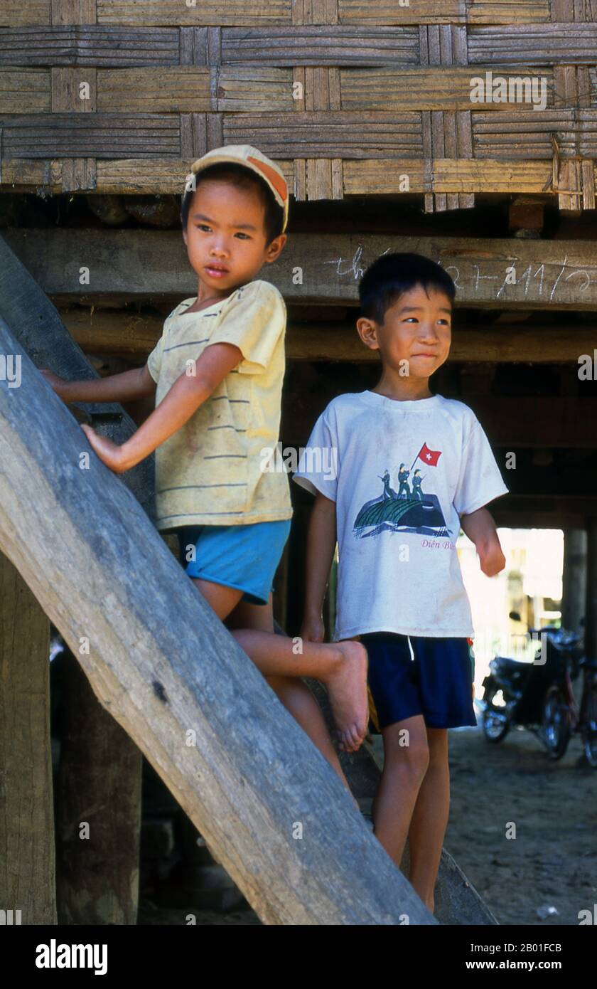 Vietnam: White Tai children near Chan Nua, 30 km south of Pa Tan, Northwest Vietnam.  In the narrow mountain valleys of Son La, Dien Bien and Lai Chau provinces of North Vietnam the Tai remain a very noticeable and confident minority. They are divided into White Tai and Black Tai communities, while further south, by the Lao frontier in Thanh Hoa and Nghe An Provinces, Red Tai predominate.  These subgroups are distinguished by the dress of their women. Vietnam’s Tai are people of the mountain valleys. Farming wet rice paddy fields they are relatively prosperous. Stock Photo