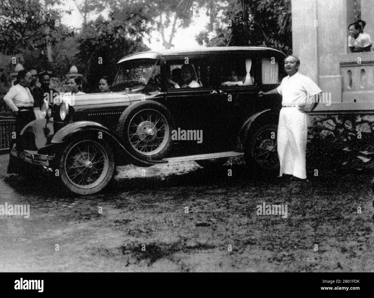 Vietnam: Deo Van Long (15 March 1887 - 20 November 1975), Lord of the Tai Federation of Sipsongchuthai, with his car, c. 1940s.  Đèo Văn Long was the White Tai leader of the Sip Song Chau Tai confederation of Northwestern Tonkin in French Indochina.  Under his father Deo Van Tri, he was the scion of a hereditary feudal noble line with roots in Yunnan. He generated much revenue for the Federation by acting as a middleman in the opium traffic between the Tai Federation and the French. He compelled the Hmong of the Federation to sell to him at below-market prices, thus making enormous profits. Stock Photo