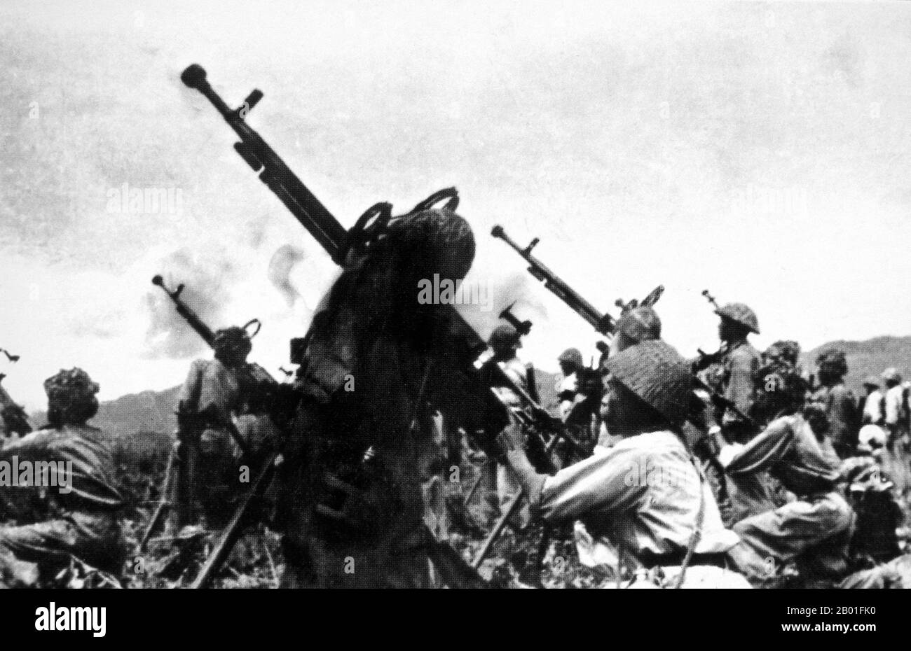 Vietnam: Viet Minh 308 Division unleashes a barrage of 12.7mm anti-aircraft fire at French planes, Dien Bien Phu, 1954.  The important Battle of Dien Bien Phu was fought between the Việt Minh (led by General Vo Nguyen Giap), and the French Union (led by General Henri Navarre, successor to General Raoul Salan). The siege of the French garrison lasted fifty-seven days, from 5:30 PM on March 13 to 5:30 PM on May 7, 1954.  The southern outpost or fire base of the camp, Isabelle, did not follow the cease-fire order and fought until the next day at 01:00 AM. Stock Photo