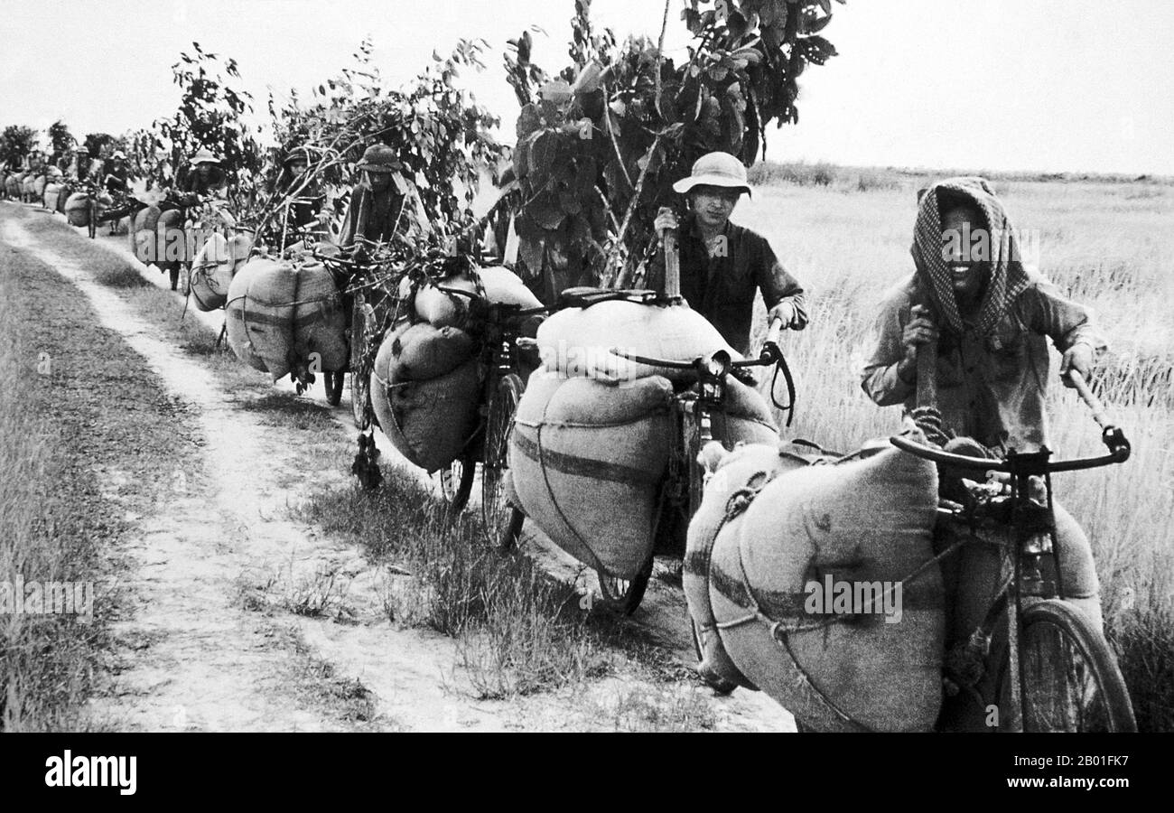 Vietnam: NLF (Viet Cong) porters taking supplies to the front near Saigon by bicycle, 1972.  The Second Indochina War, known in America as the Vietnam War, was a Cold War era military conflict that occurred in Vietnam, Laos, and Cambodia from 1 November 1955 to the fall of Saigon on 30 April 1975. This war followed the First Indochina War and was fought between North Vietnam, supported by its communist allies, and the government of South Vietnam, supported by the U.S. and other anti-communist nations. Stock Photo