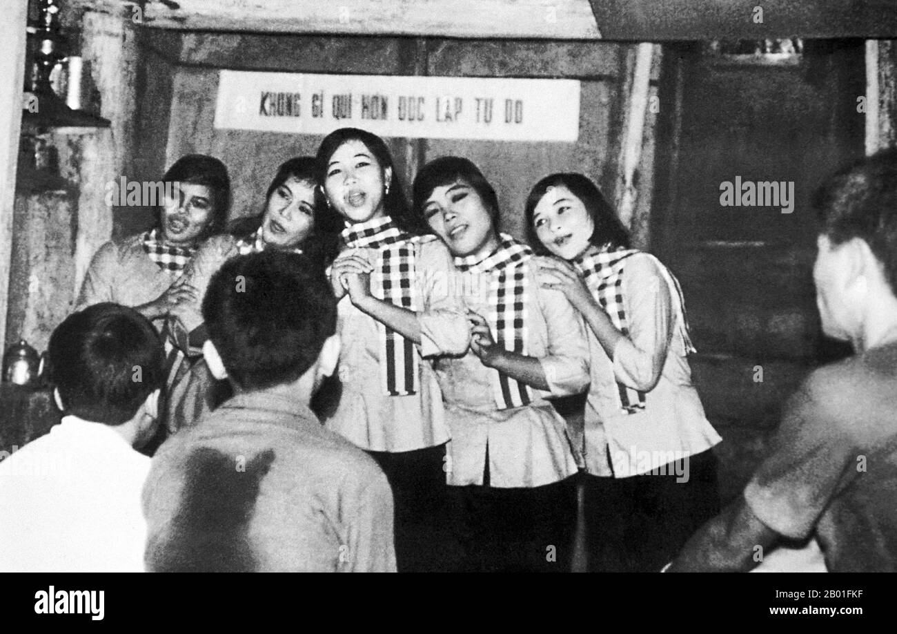 Vietnam: NLF (Viet Cong) female folk dance group singing underground at Cu Chi, 1972.  The Second Indochina War, known in America as the Vietnam War, was a Cold War era military conflict that occurred in Vietnam, Laos, and Cambodia from 1 November 1955 to the fall of Saigon on 30 April 1975. This war followed the First Indochina War and was fought between North Vietnam, supported by its communist allies, and the government of South Vietnam, supported by the U.S. and other anti-communist nations. The U.S. government viewed involvement in the war as a way to prevent a communist takeover. Stock Photo