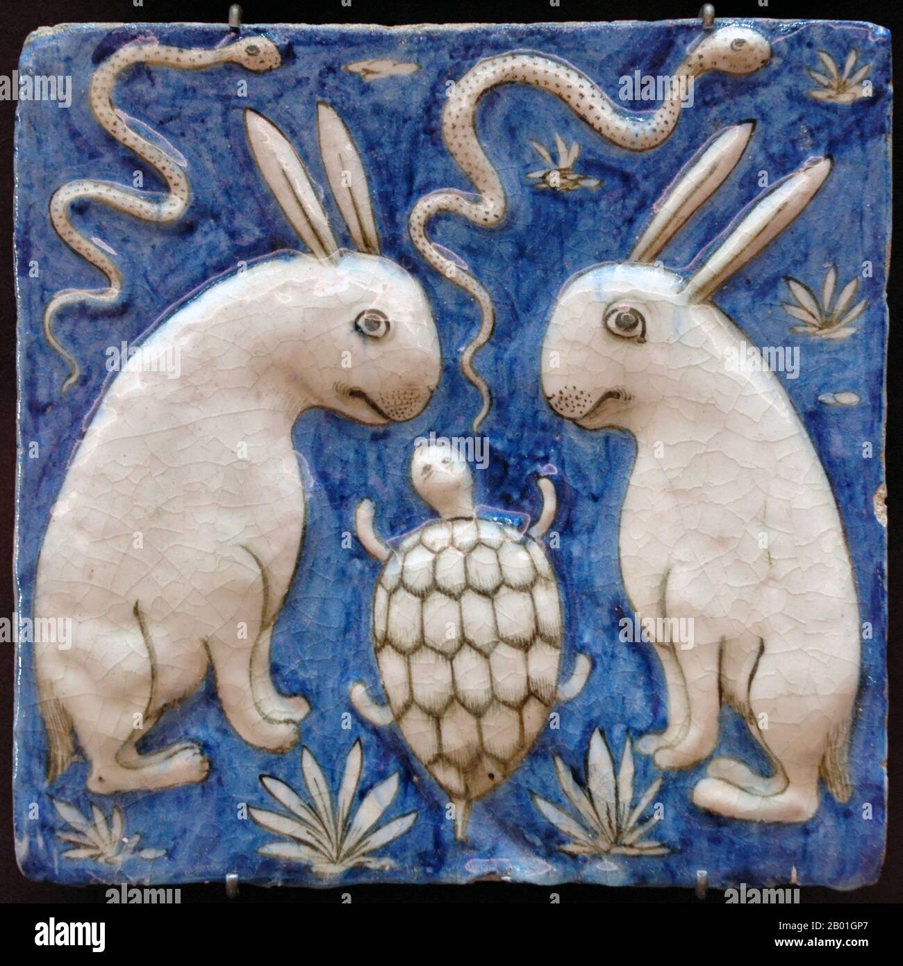 Iran/Persia: A ceramic tile with two rabbits, two snakes and a tortoise. Illustration from Zakarīyā ibn Muḥammad al-Qazwīnī, ‘Ajā’ib al-makhlūqāt wa-gharā’ib al-mawjūdāt (Marvels of Things Created and Miraculous Aspects of Things Existing, 1537-1538 CE). Earthenware, molded and underglaze-painted decoration, 19th century  Abu Yahya Zakariya' ibn Muhammad al-Qazwini (1203-1283), was a Persian physician, astronomer, geographer and proto-science fiction writer. Stock Photo