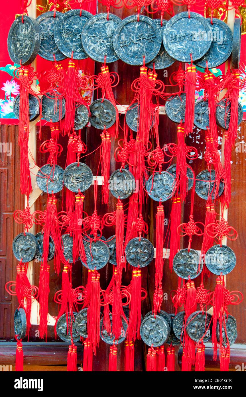 China: Solid blocks of tea hang as pendants outside a tea shop, Old Town, Lijiang, Yunnan Province.  According to oral tradition, tea has been grown in China for more than four millennia. The earliest written accounts of tea making, however, date from around 350 CE, when it first became a drink at the imperial court.  Around 800 CE tea seeds were taken to Japan, where regular cultivation was soon established. Just over five centuries later, in 1517, tea was first shipped to Europe by the Portuguese soon after they began their trade with China. Stock Photo