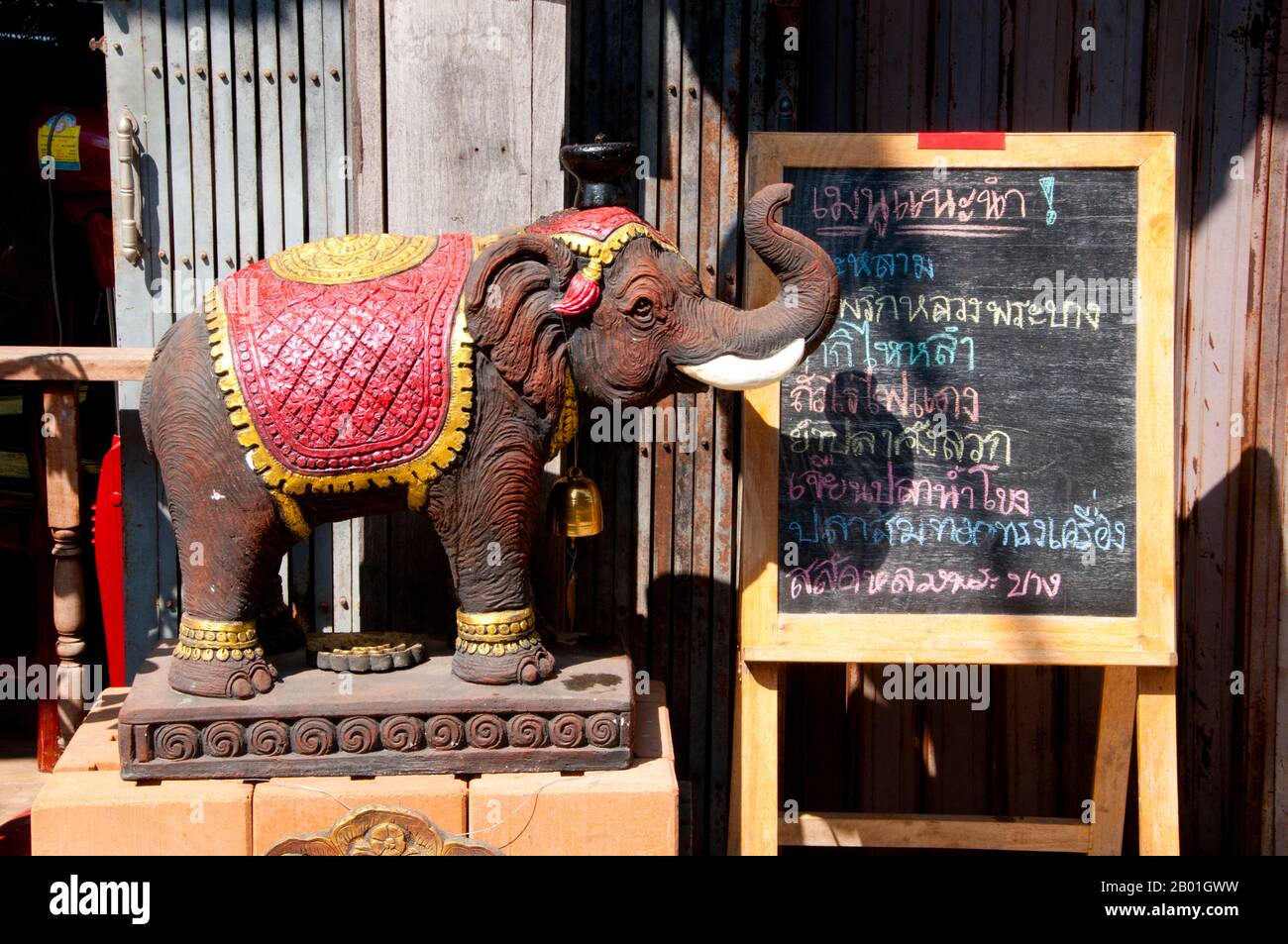 Thailand: Wooden elephant and menu outside a restaurant on Chai Kong Road, Chiang Khan, Loei Province.  Loei (Thai: เลย) Province is located in Thailand's upper North-East. Neighboring provinces are (from east clockwise) Nong Khai, Udon Thani, Nongbua Lamphu, Khon Kaen, Phetchabun, Phitsanulok. In the north it borders Xaignabouli and Vientiane Provinces of Laos.  The province is covered with low mountains, while the capital Loei is located in a fertile basin. The Loei River, which flows through the province, is a tributary of the Mekong. Stock Photo