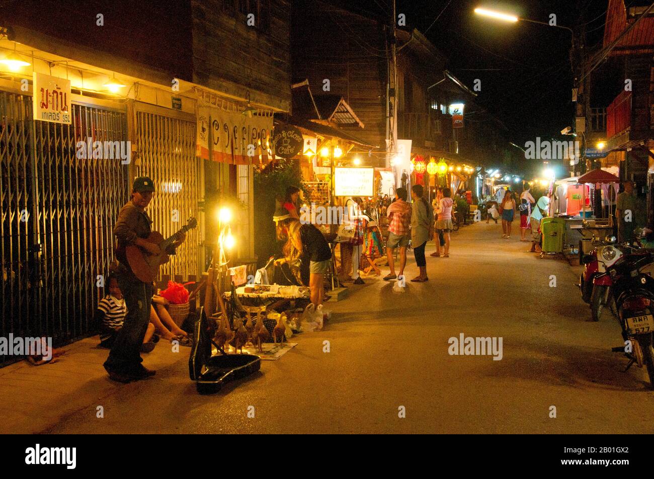 Thailand: Street musician entertaining late evening shoppers on Chai Kong Road, Chiang Khan, Loei Province.  Loei (Thai: เลย) Province is located in Thailand's upper North-East. Neighboring provinces are (from east clockwise) Nong Khai, Udon Thani, Nongbua Lamphu, Khon Kaen, Phetchabun, Phitsanulok. In the north it borders Xaignabouli and Vientiane Provinces of Laos.  The province is covered with low mountains, while the capital Loei is located in a fertile basin. The Loei River, which flows through the province, is a tributary of the Mekong. Stock Photo