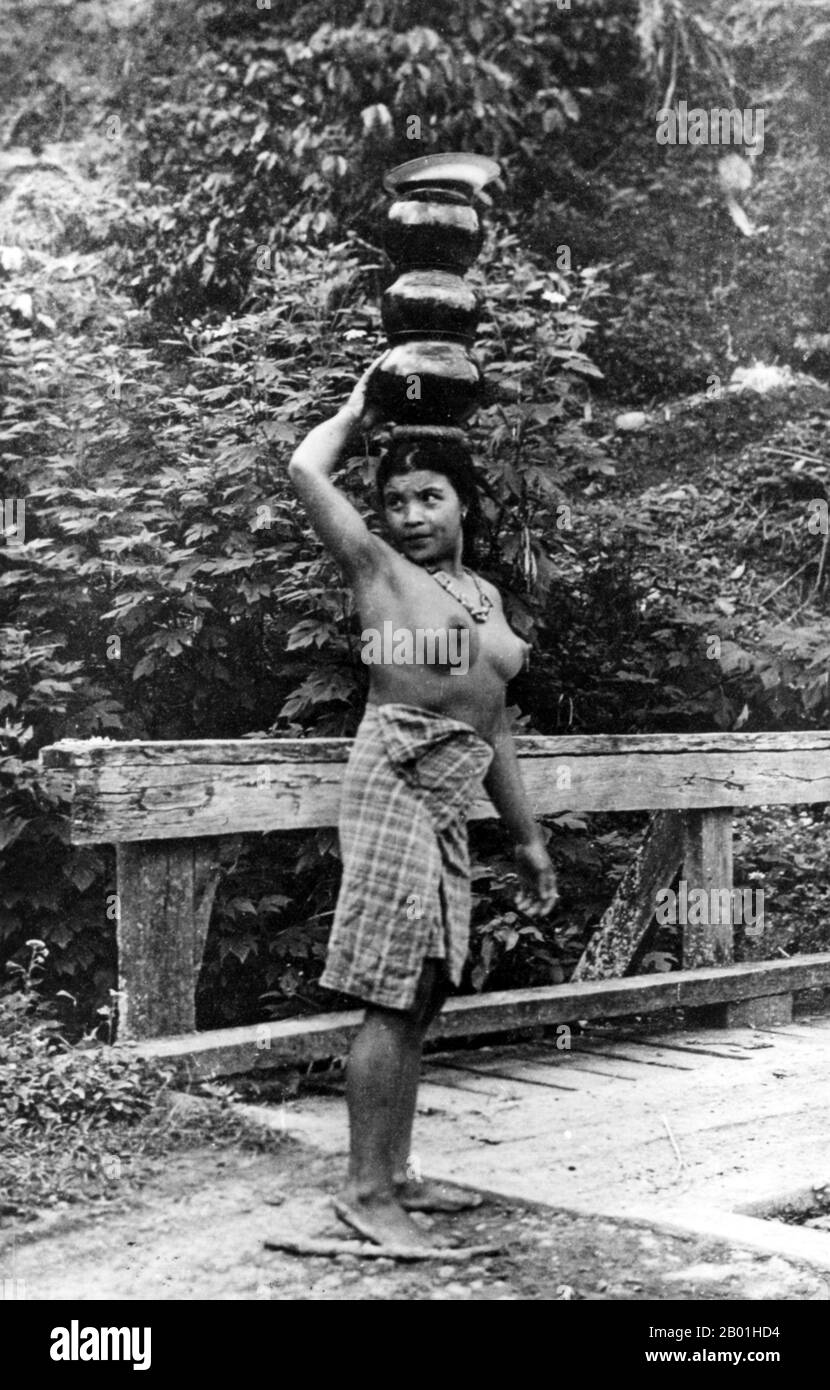 Philippines: Ifugao woman balancing pots on her head about to cross a bridge, Cordillera Administrative Region, Central Luzon. Photo by Eduardo Masferré, Bertil Lintner Collection, c. 1950.  Ifugao is a landlocked province of the Philippines in the Cordillera Administrative Region in Luzon. Covering a total land area of 262,820 hectares, the province of Ifugao is located in a mountainous region characterised by rugged terrain, river valleys and massive forests. Its capital is Lagawe and borders Benguet to the west, Mountain Province to the north, Isabela to the east and Nueva Vizcaya to the s Stock Photo