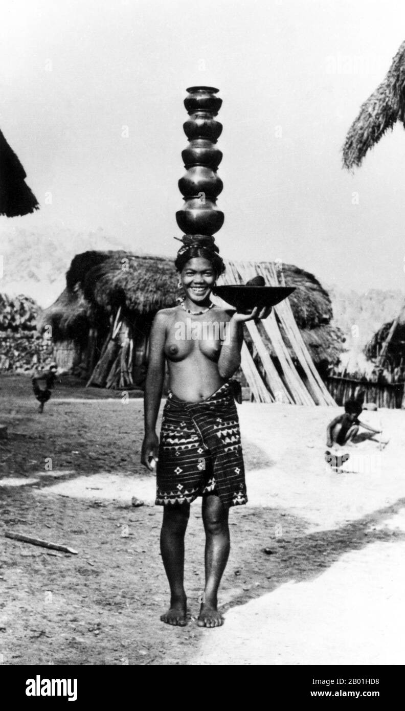 Philippines: Ifugao woman carrying a bowl in one hand with a stack of five bowls balanced on her head, Cordillera Administrative Region, Central Luzon. Photo by Eduardo Masferré, Bertil Lintner Collection, c. 1950.  Ifugao is a landlocked province of the Philippines in the Cordillera Administrative Region, Luzon. Covering a total land area of 262,820 hectares, the province of Ifugao is located in a mountainous region characterised by rugged terrain, river valleys and massive forests. Its capital is Lagawe and borders Benguet to the west, Mountain Province to the north, Isabela to the south. Stock Photo