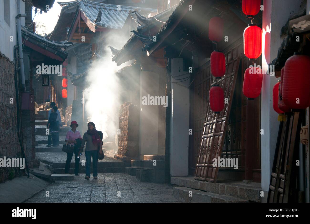 China: A smoky back street, Lijiang Old Town, Yunnan Province.  The Naxi or Nakhi are an ethnic group inhabiting the foothills of the Himalayas in the northwestern part of Yunnan Province, as well as the southwestern part of Sichuan Province in China. The Naxi are thought to have come originally from Tibet and, until recently, maintained overland trading links with Lhasa and India.  The Naxi form one of the 56 ethnic groups officially recognised by the People's Republic of China. The Naxi are traditionally followers of the Dongba religion. Stock Photo