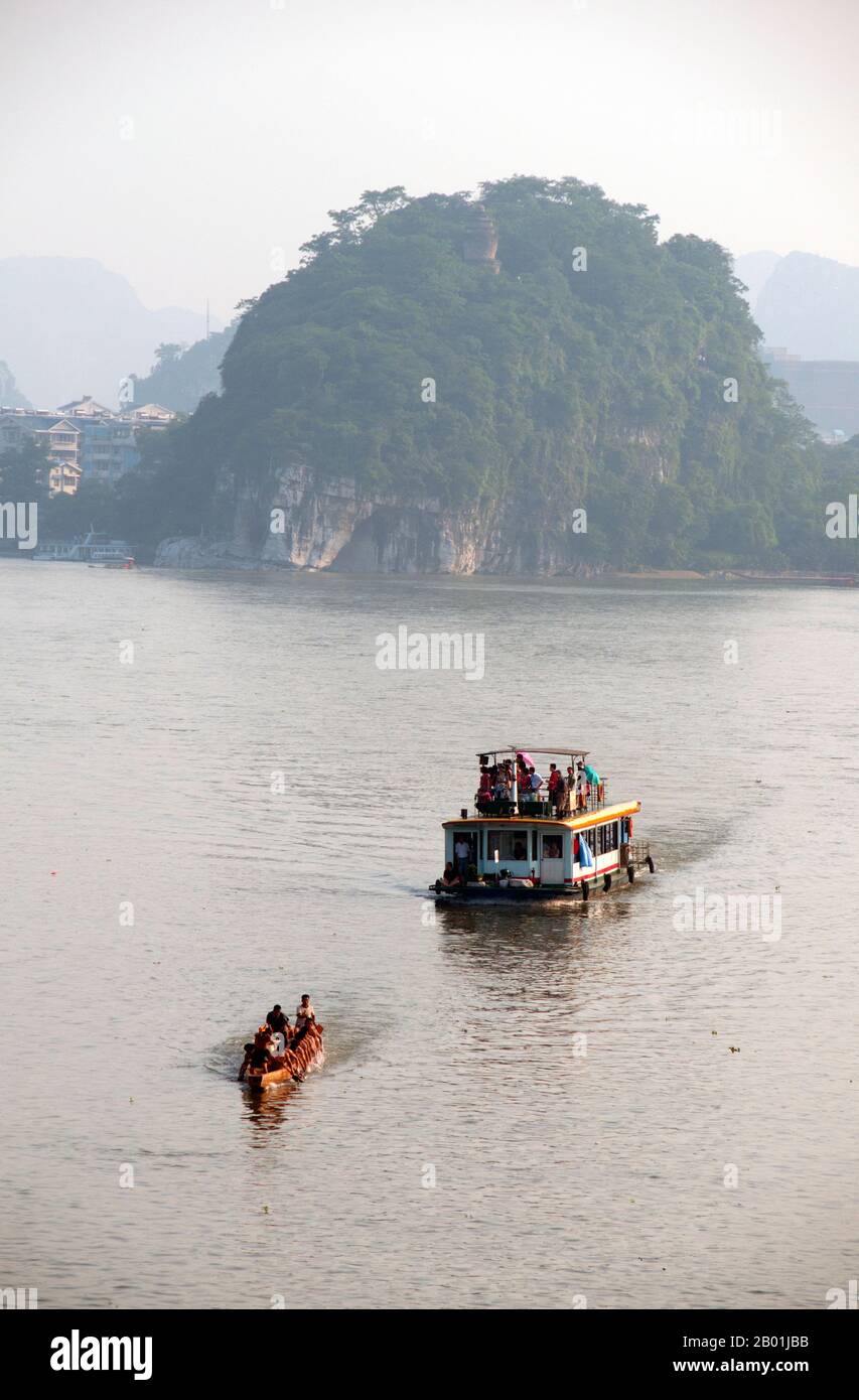 China: Boats on the Li River, Guilin, Guangxi Province.  Guilin's Dragon Boat Festival is held on the fifth day of the fifth month (May) of the Chinese lunar calendar every 3 years. The festival was originally held in memory of the great Chinese poet, Quyuan.  The name Guilin means ‘Cassia Woods’ and is named after the osmanthus (cassia) blossoms that bloom throughout the autumn period.  Guilin is the scene of China’s most famous landscapes, inspiring thousands of paintings over many centuries. Stock Photo