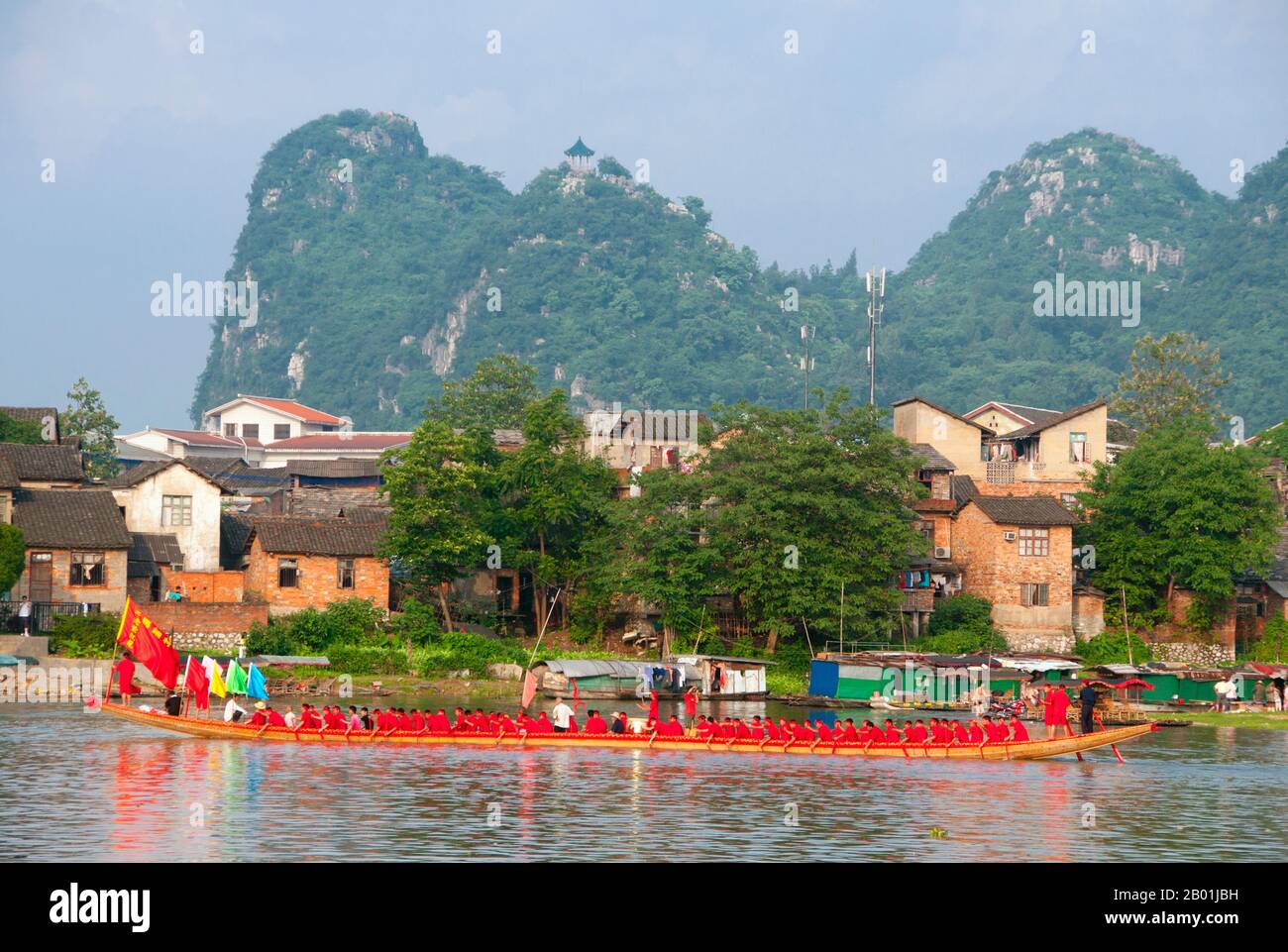 China: Dragon boat on the Li River with Seven Star Park in the background, Guilin, Guangxi Province.  Guilin's Dragon Boat Festival is held on the fifth day of the fifth month (May) of the Chinese lunar calendar every 3 years. The festival was originally held in memory of the great Chinese poet, Quyuan.  The name Guilin means ‘Cassia Woods’ and is named after the osmanthus (cassia) blossoms that bloom throughout the autumn period.  Guilin is the scene of China’s most famous landscapes, inspiring thousands of paintings over many centuries. Stock Photo
