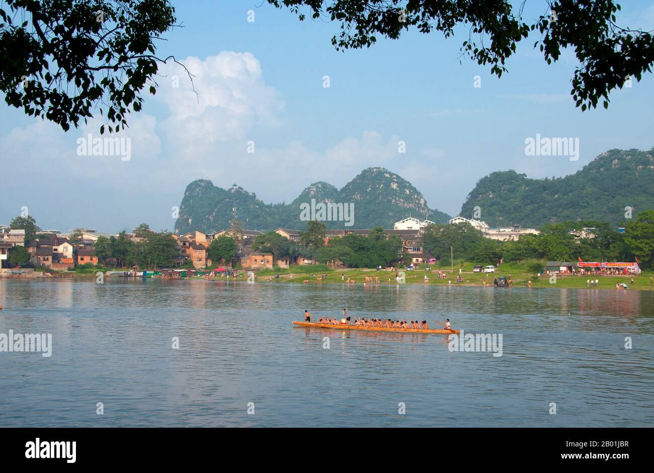 China: Dragon boat on the Li River with Seven Star Park in the background, Guilin, Guangxi Province.  Guilin's Dragon Boat Festival is held on the fifth day of the fifth month (May) of the Chinese lunar calendar every 3 years. The festival was originally held in memory of the great Chinese poet, Quyuan.  The name Guilin means ‘Cassia Woods’ and is named after the osmanthus (cassia) blossoms that bloom throughout the autumn period.  Guilin is the scene of China’s most famous landscapes, inspiring thousands of paintings over many centuries. Stock Photo