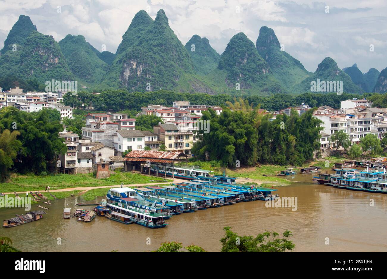 China: Boats on the Li River at Yangshuo, near Guilin, Guangxi Province.  Yangshuo is rightly famous for its dramatic scenery. It lies on the west bank of the Li River (Lijiang) and is just 60 kms downstream from Guilin. Over recent years it has become a popular destination with tourists whilst also retaining its small river town feel.  Guilin is the scene of China’s most famous landscapes, inspiring thousands of paintings over many centuries. The ‘finest mountains and rivers under heaven’ are so inspiring that poets, artists and tourists have made this China’s number one natural attraction. Stock Photo