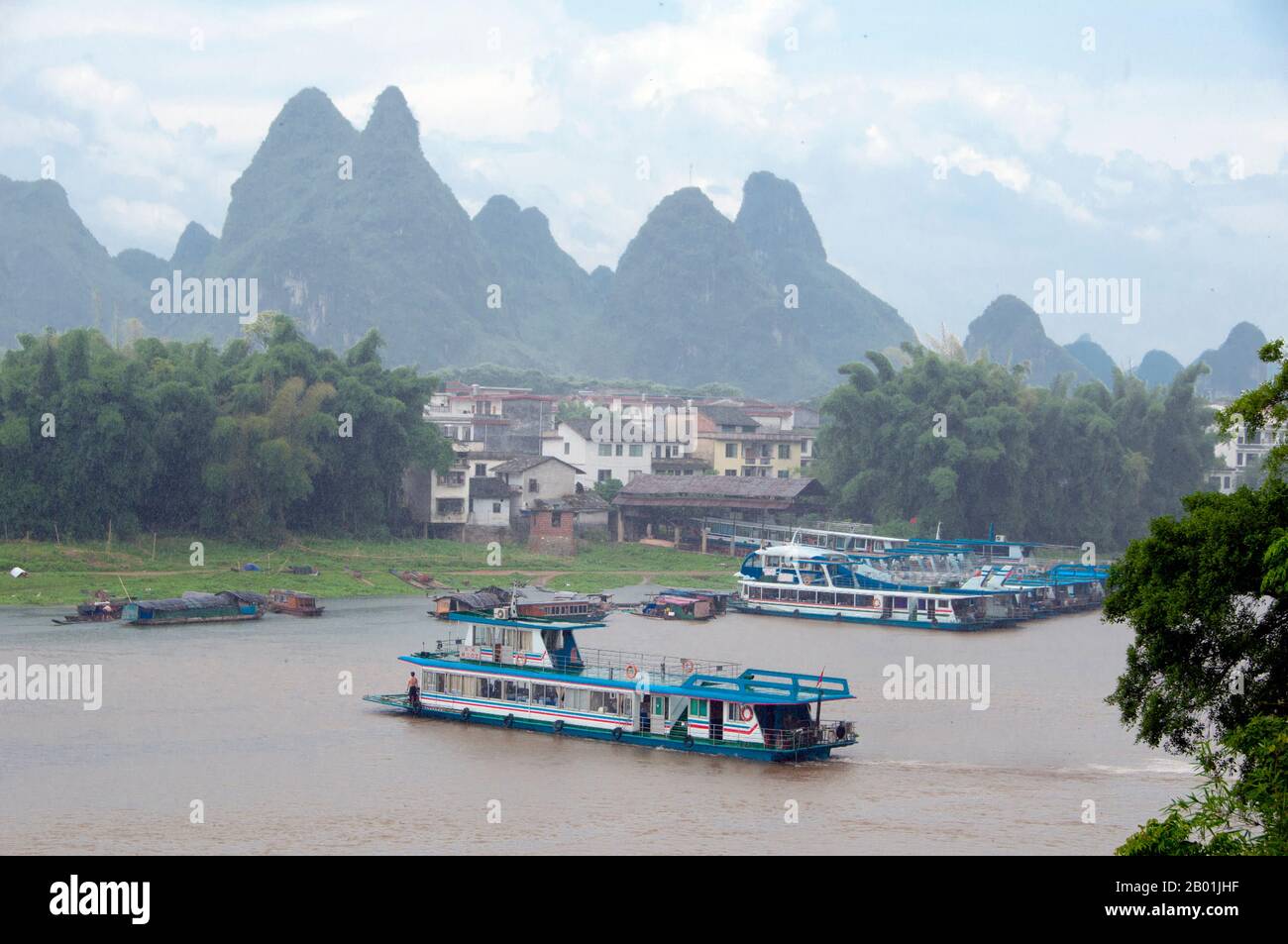 China: Boats on the Li River at Yangshuo, near Guilin, Guangxi Province.  Yangshuo is rightly famous for its dramatic scenery. It lies on the west bank of the Li River (Lijiang) and is just 60 kms downstream from Guilin. Over recent years it has become a popular destination with tourists whilst also retaining its small river town feel.  Guilin is the scene of China’s most famous landscapes, inspiring thousands of paintings over many centuries. The ‘finest mountains and rivers under heaven’ are so inspiring that poets, artists and tourists have made this China’s number one natural attraction. Stock Photo