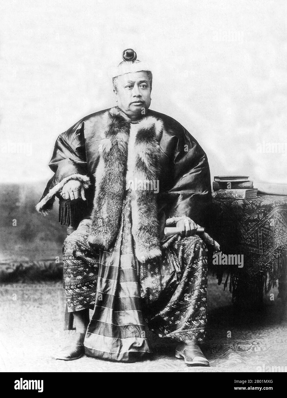 Burma/Myanmar: A Bamar official dressed in silk 'pasoe' and fur jacket to indicate rank, late 19th century.  The British conquest of Burma began in 1824 in response to a Burmese attempt to invade India. By 1886, and after two further wars, Britain had incorporated the entire country into the British Raj. To stimulate trade and facilitate changes, the British brought in Indians and Chinese, who quickly displaced the Burmese in urban areas. To this day Rangoon and Mandalay have large ethnic Indian populations. Railways and schools were built, as well as a large number of prisons. Stock Photo