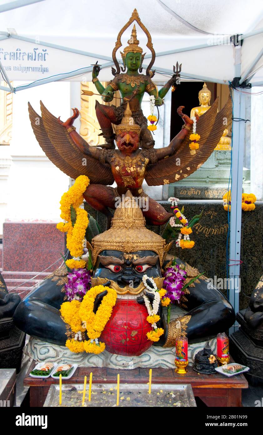 Thailand: Krut Pha (top), a garuda carrying the Hindu god Vishnu, and Rahu (Snake Demon and causer of solar and lunar eclipses), swallowing the moon, Wat Traimit, Bangkok. The National Emblem (National Symbol) of Thailand features the Garuda, a figure from both Buddhist and Hindu mythology. In Thailand, this figure is used as a symbol of the royal family and authority. This version of the figure is referred to as Krut Pha, meaning 'garuḍa acting as the vehicle (of Vishnu).'  In Hindu mythology, Rahu is a snake that swallows the sun or the moon causing eclipses. Stock Photo