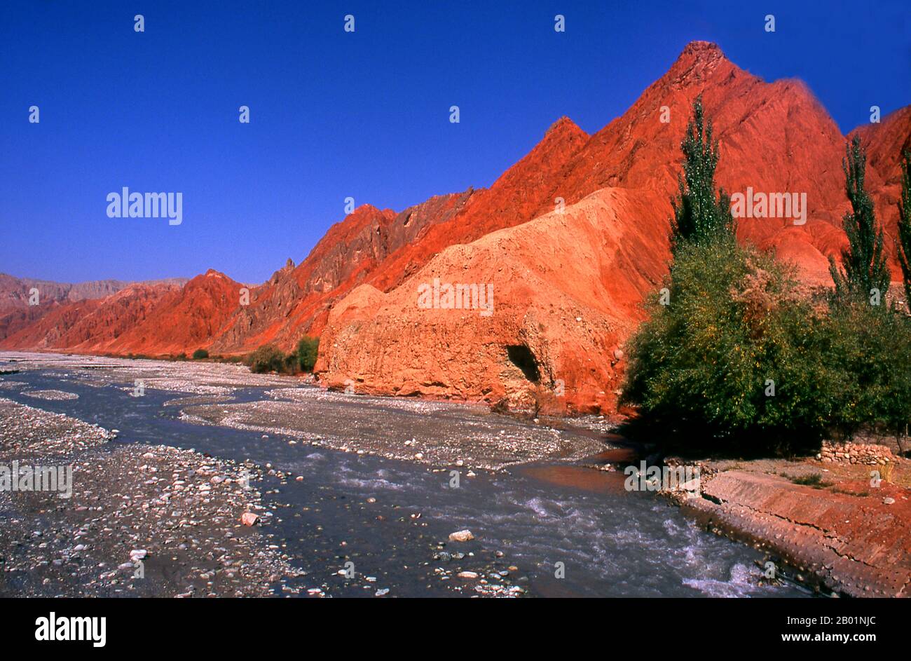 China: The red mountains of the Ghez River (Ghez Darya) canyon, Karakoram Highway, Xinjiang.  The Zhongba Gonglu or Karakoram Highway is an engineering marvel that was opened in 1986 and remains the highest paved road in the world. It connects China and Pakistan across the Karakoram mountain range, through the Khunjerab Pass, at an altitude of 4,693 m/15,397 ft. Stock Photo