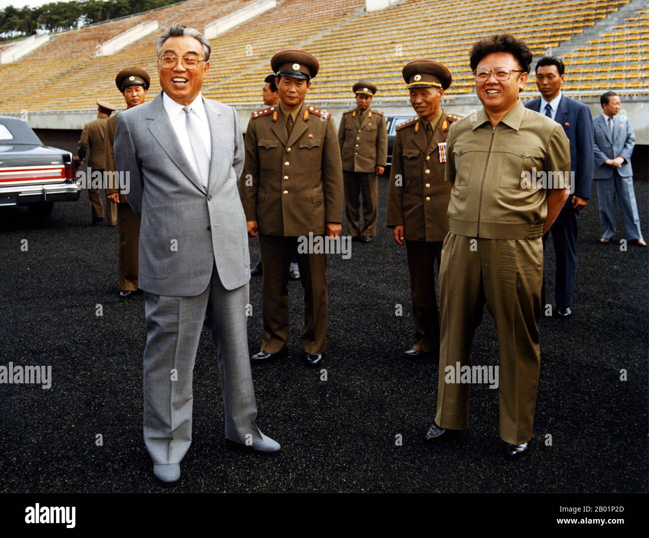 Korea: North Korean leader Kim Il Sung (15 April 1912 - 8 July 1994) at a football stadium wth his heir and successor Kim Jong Il, c. 1985.  Kim Il-sung was a Korean communist politician who ruled North Korea, officially the Democratic People's Republic of Korea, from its establishment in 1948 until his death in 1994. He held the posts of Prime Minister from 1948 to 1972 and President from 1972 to his death. He was also the leader of the Workers' Party of Korea from 1949 to 1994 (titled as chairman from 1949 to 1966 and as general secretary after 1966). Stock Photo