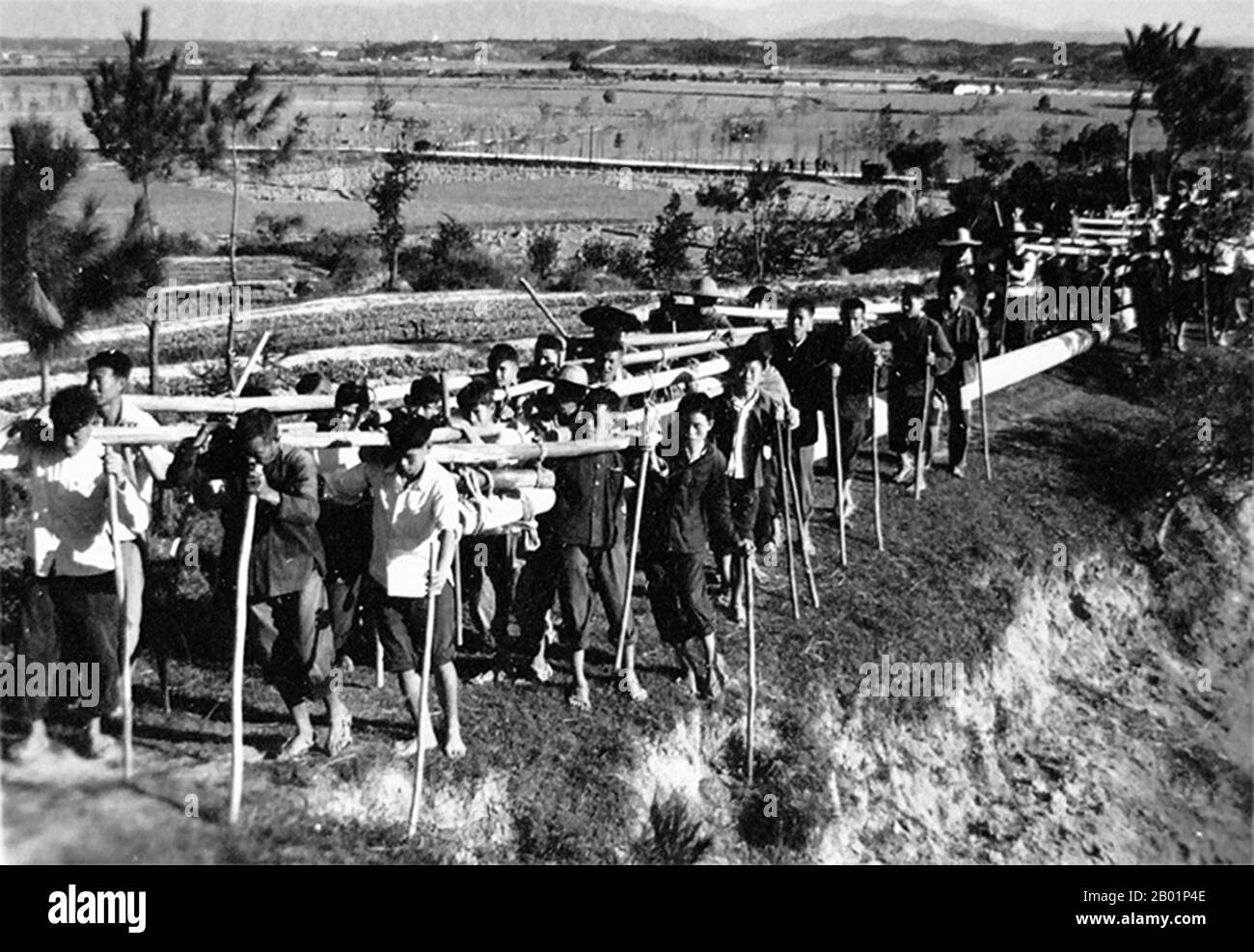 China: Male commune team carrying heavy stones during the Great Leap Forward (1958-1961).  The Great Leap Forward of the People's Republic of China (PRC) was an economic and social campaign of the Communist Party of China (CPC), reflected in planning decisions from 1958 to 1961, which aimed to use China's vast population to rapidly transform the country from an agrarian economy into a modern communist society through the process of rapid industrialisation, and collectivisation. Mao Zedong led the campaign based on the Theory of Productive Forces. Stock Photo