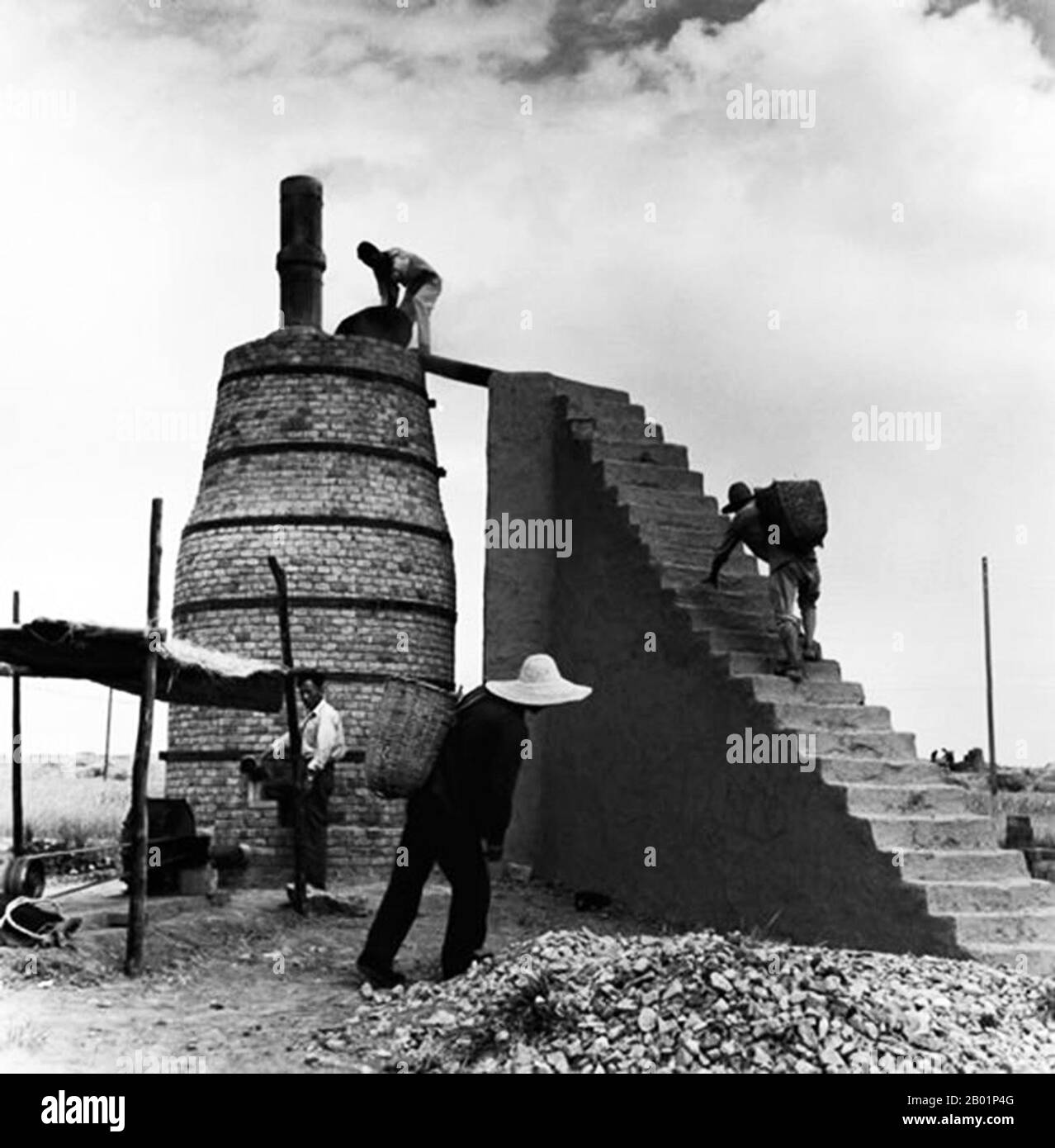 China: A team of men working on a backyard furnace during the Great Leap Forward (1958-1961).  The Great Leap Forward of the People's Republic of China (PRC) was an economic and social campaign of the Communist Party of China (CPC), reflected in planning decisions from 1958 to 1961, which aimed to use China's vast population to rapidly transform the country from an agrarian economy into a modern communist society through the process of rapid industrialisation, and collectivisation. Mao Zedong led the campaign based on the Theory of Productive Forces. Stock Photo