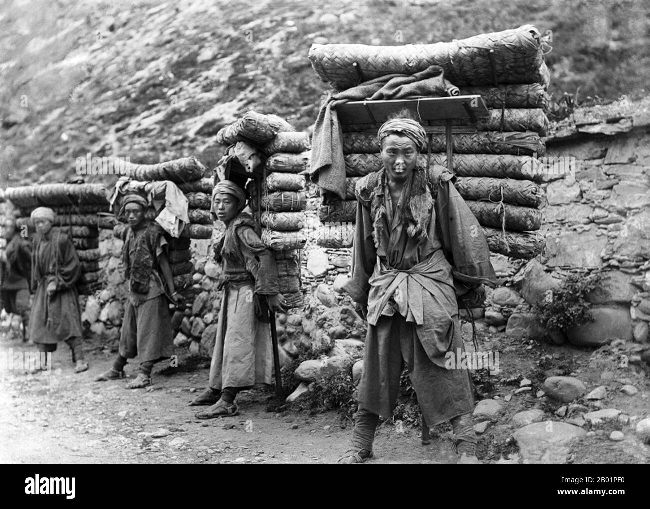 China: Tea Porters on Tea Horse Road, Western Sichuan, early 1900s.  The Tea Horse Road (Cha Ma Dao) was a network of mule caravan paths winding through the mountains of Yunnan, Sichuan and Tibet in Southwest China. It is also sometimes referred to as the Southern Silk Road and Ancient Tea and Horse Road.  From around a thousand years ago, the Ancient Tea Route was a trade link from Yunnan, one of the first tea-producing regions, to India via Burma, to Tibet and to central China via Sichuan Province. In addition to tea, the mule caravans carried salt. Stock Photo