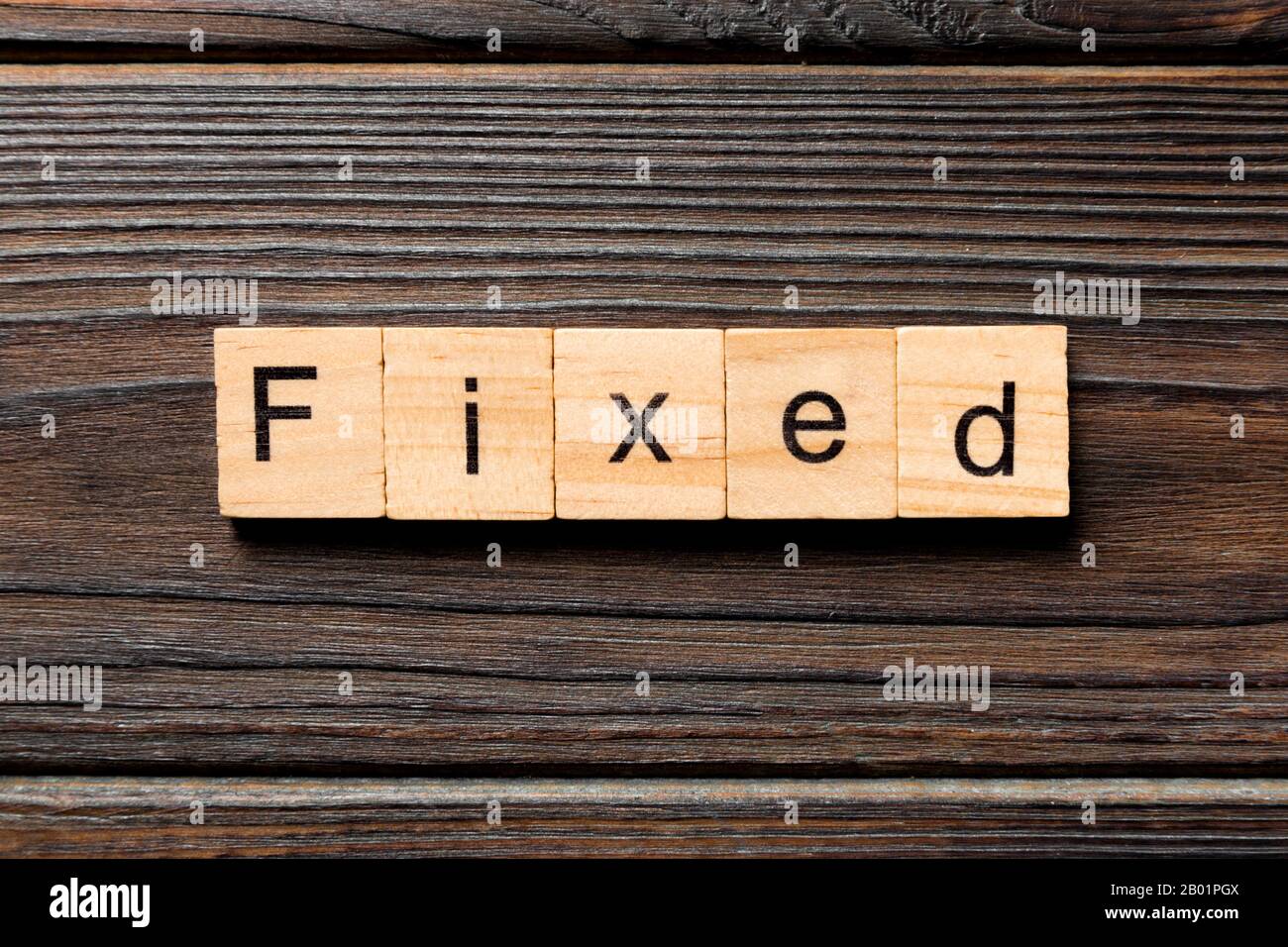 fixed word written on wood block. fixed text on table, concept. Stock Photo