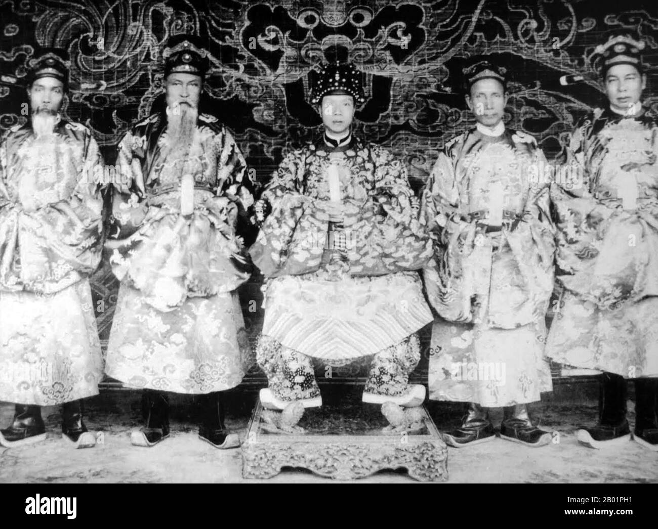 Vietnam: Emperor Khai Dinh (8 October 1885 - 6 November 1925), 12th emperor of the Nguyen Dynasty, with four court mandarins, 1919.  Emperor Khải Định was the 12th Emperor of the Nguyễn Dynasty in Vietnam. His name at birth was Prince Nguyễn Phúc Bửu Đảo. He was the son of Emperor Đồng Khánh, but he did not succeed him immediately. He reigned only nine years: 1916-1925. Stock Photo