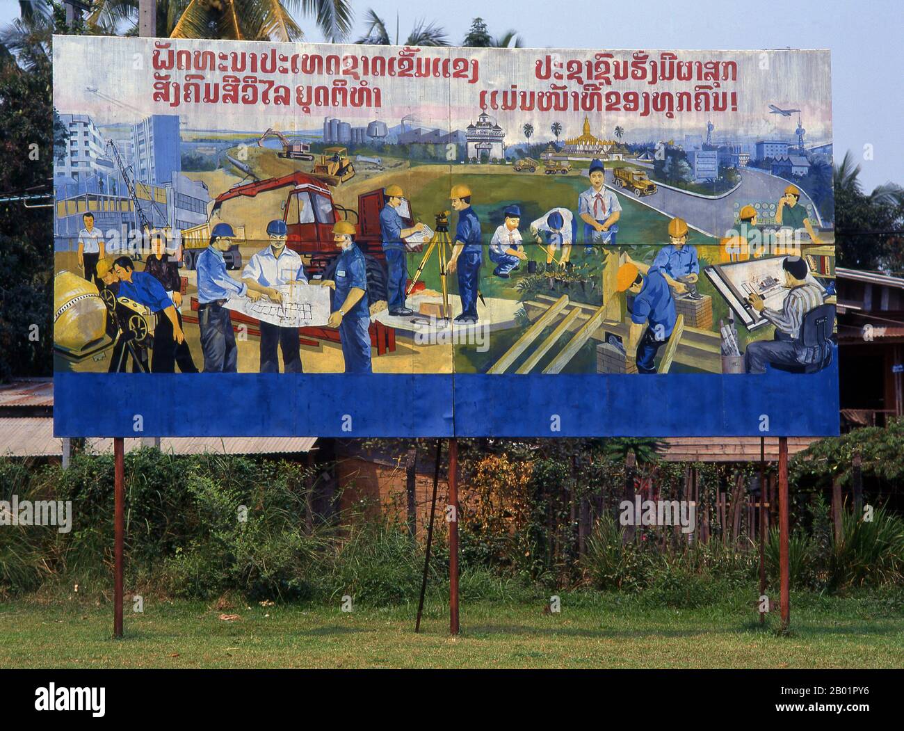 Laos: Construction and industry in Laos. Revolutionary Socialist realist-style political poster on the streets of Vientiane.  Socialist realism is a style of realistic art which was developed in the Soviet Union and became a dominant style in other communist countries. Socialist realism is a teleologically-oriented style having its purpose the furtherance of the goals of socialism and communism. Although related, it should not be confused with social realism, a type of art that realistically depicts subjects of social concern. Stock Photo
